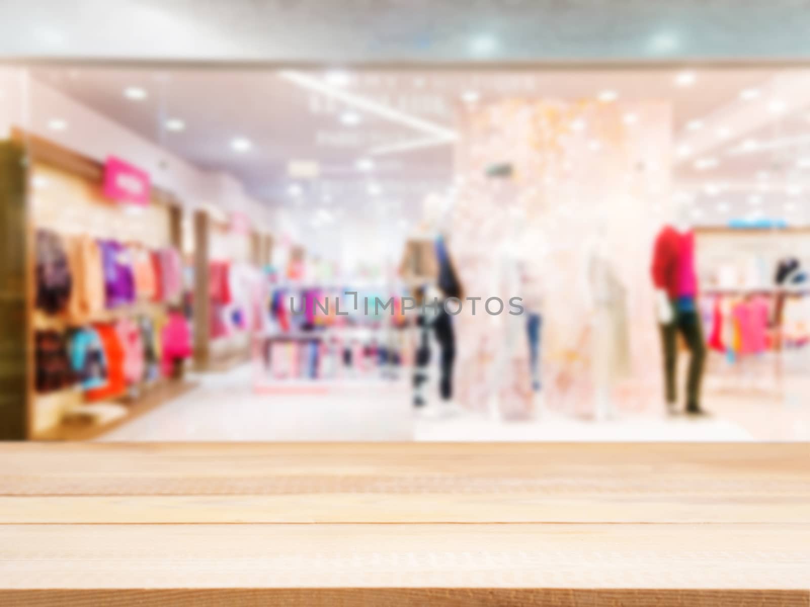 Wooden board empty table in front of blurred background. Perspective light wood table over blur in dress store. Mock up for display or montage your product.