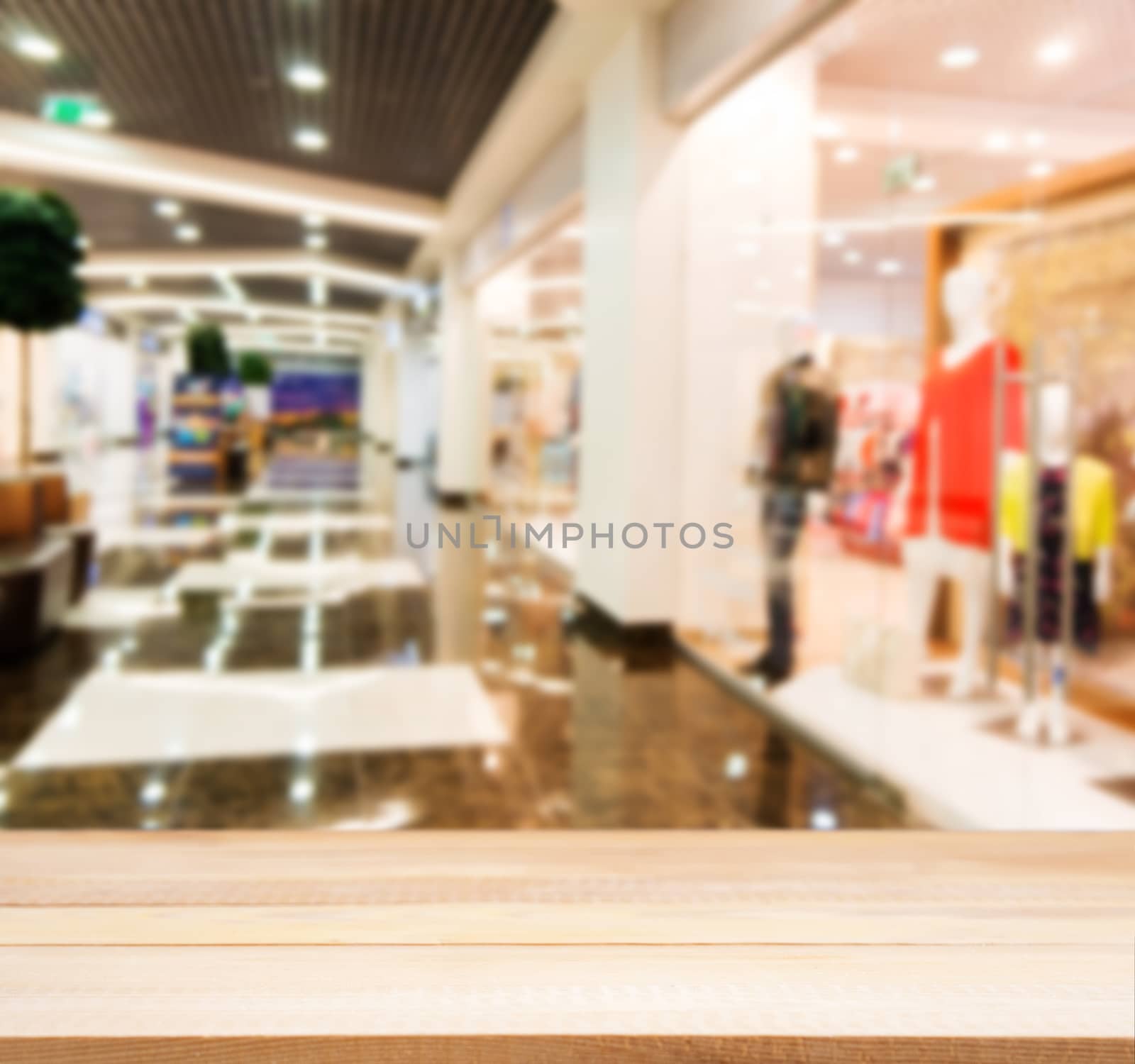 Wooden board empty table in front of blurred background. Perspective light wood table over blur in shopping mall hall. Mock up for display or montage your product.