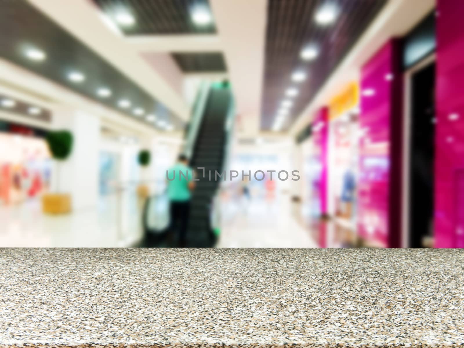 Marble board empty table in front of blurred background. Perspective marble table over blur in shopping mall hall. Mock up for display or montage your product.