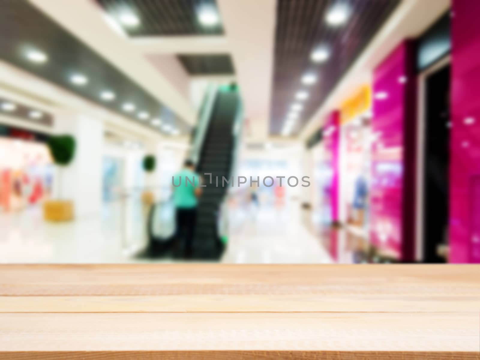 Wooden empty table in front of blurred mall by fascinadora