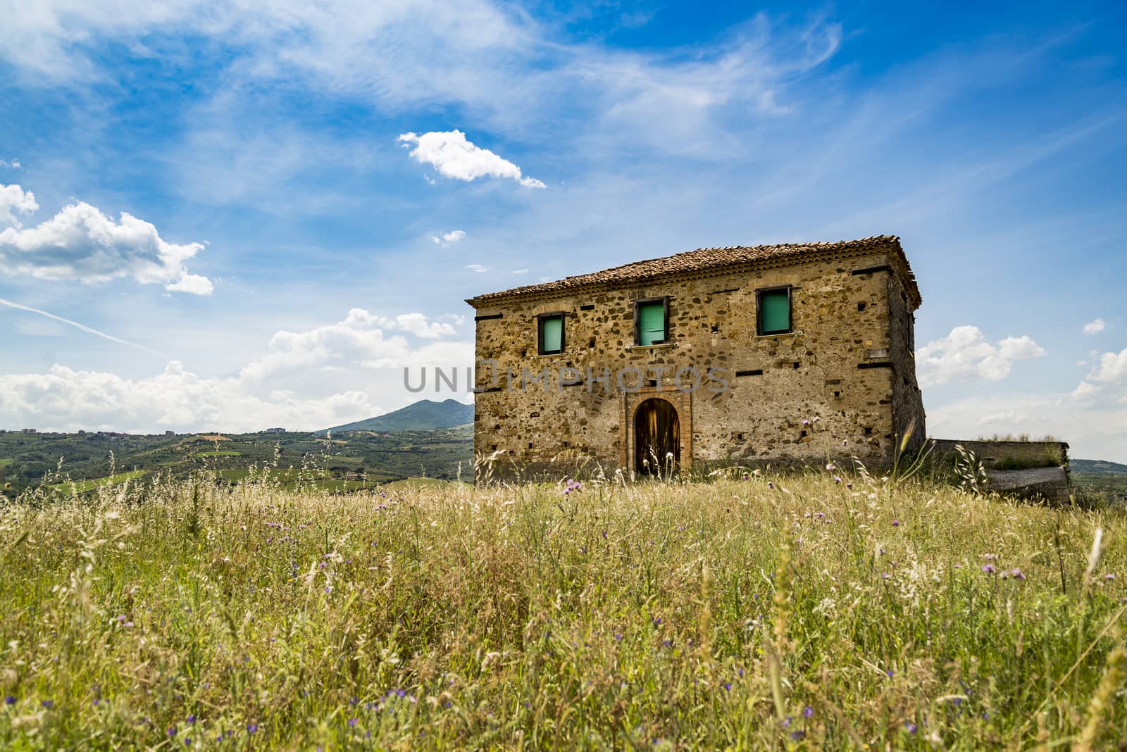 Hilly landscape with abandoned farm house in Basilicata region in Italy