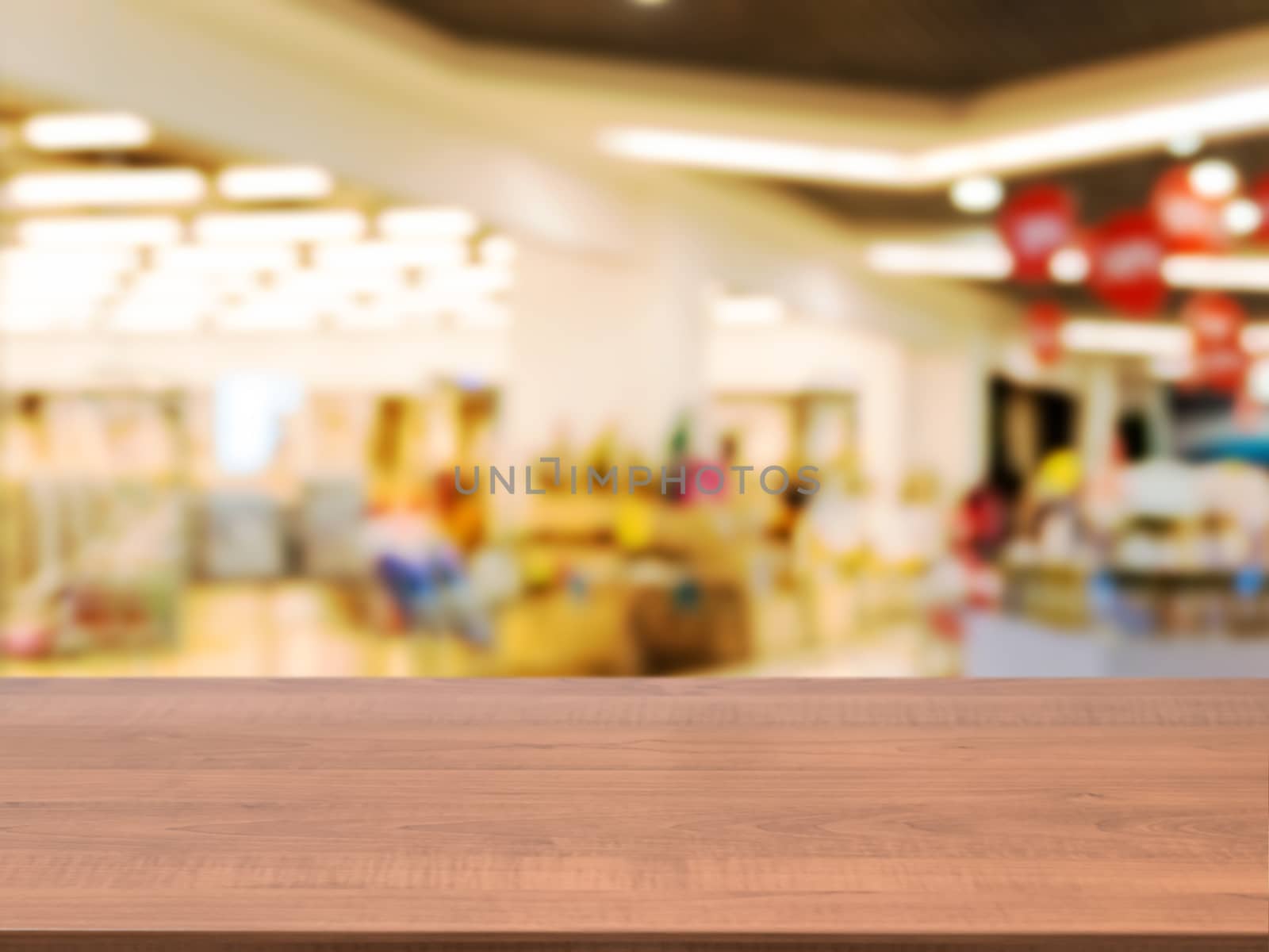 Wooden board empty table in front of blurred background. Perspective light wood table over blur in shopping mall hall. Mock up for display or montage your product.