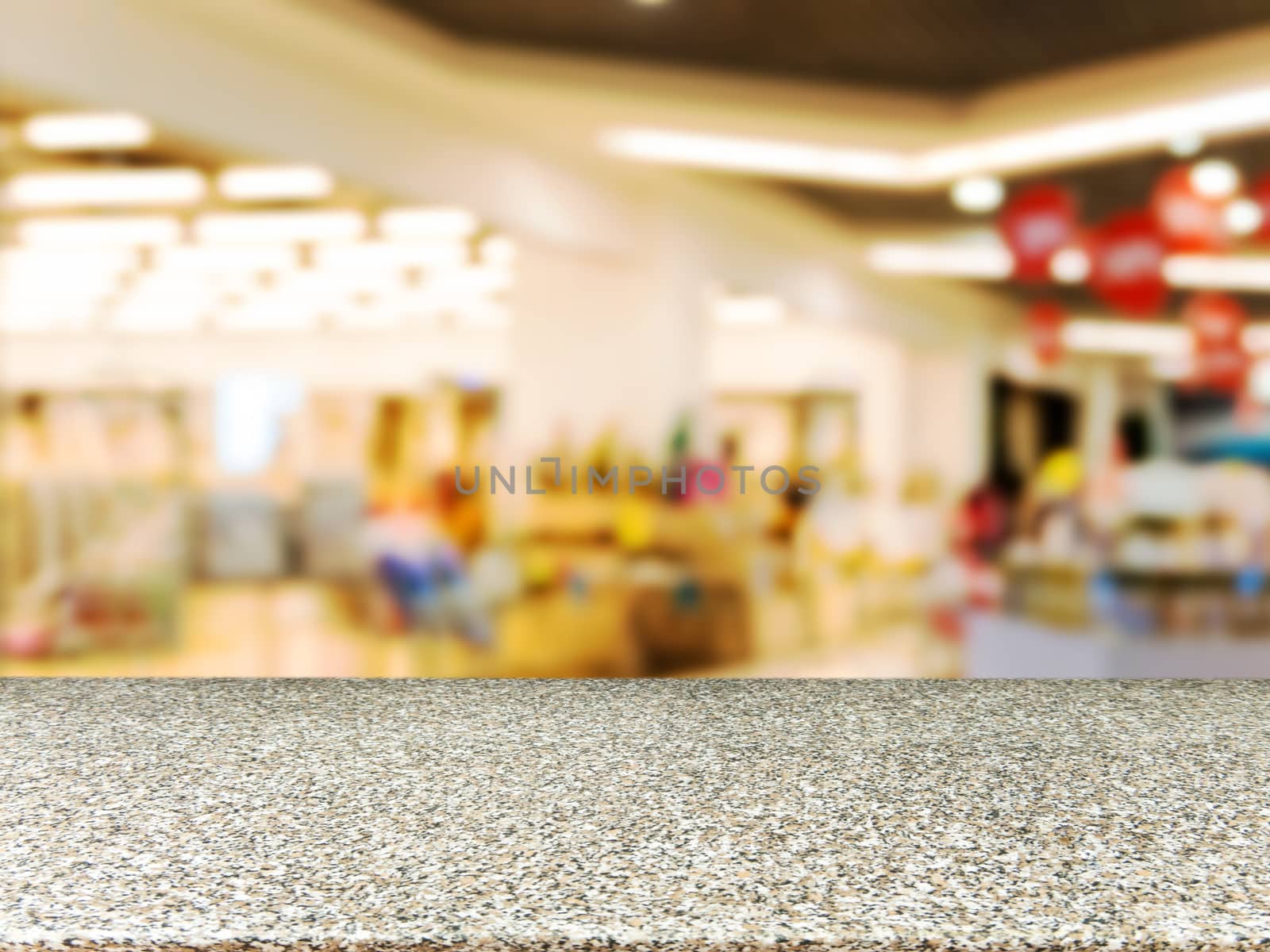 Marble board empty table in front of blurred background. Perspective marble table over blur in shopping mall hall. Mock up for display or montage your product.