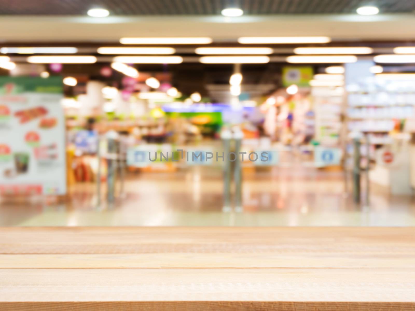 Wooden board empty table in front of blurred background. Perspective light wood over blur in entrance area of supermarket. Mock up for display or montage your product.
