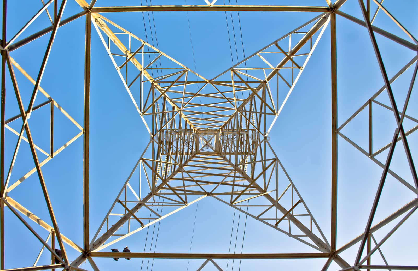 High section of electric power line pylon against blue sky