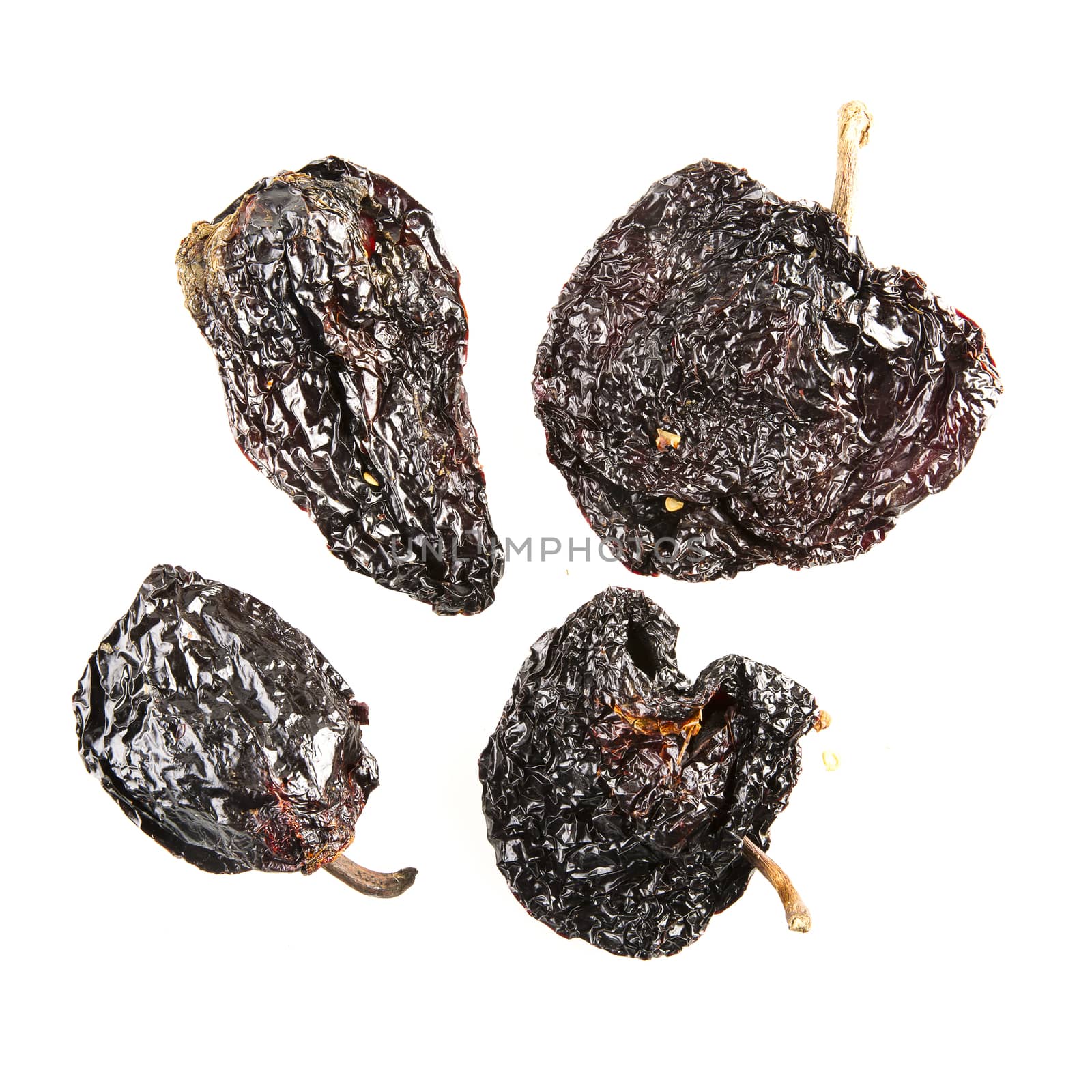 Four dried poblano chilies isolated on white.