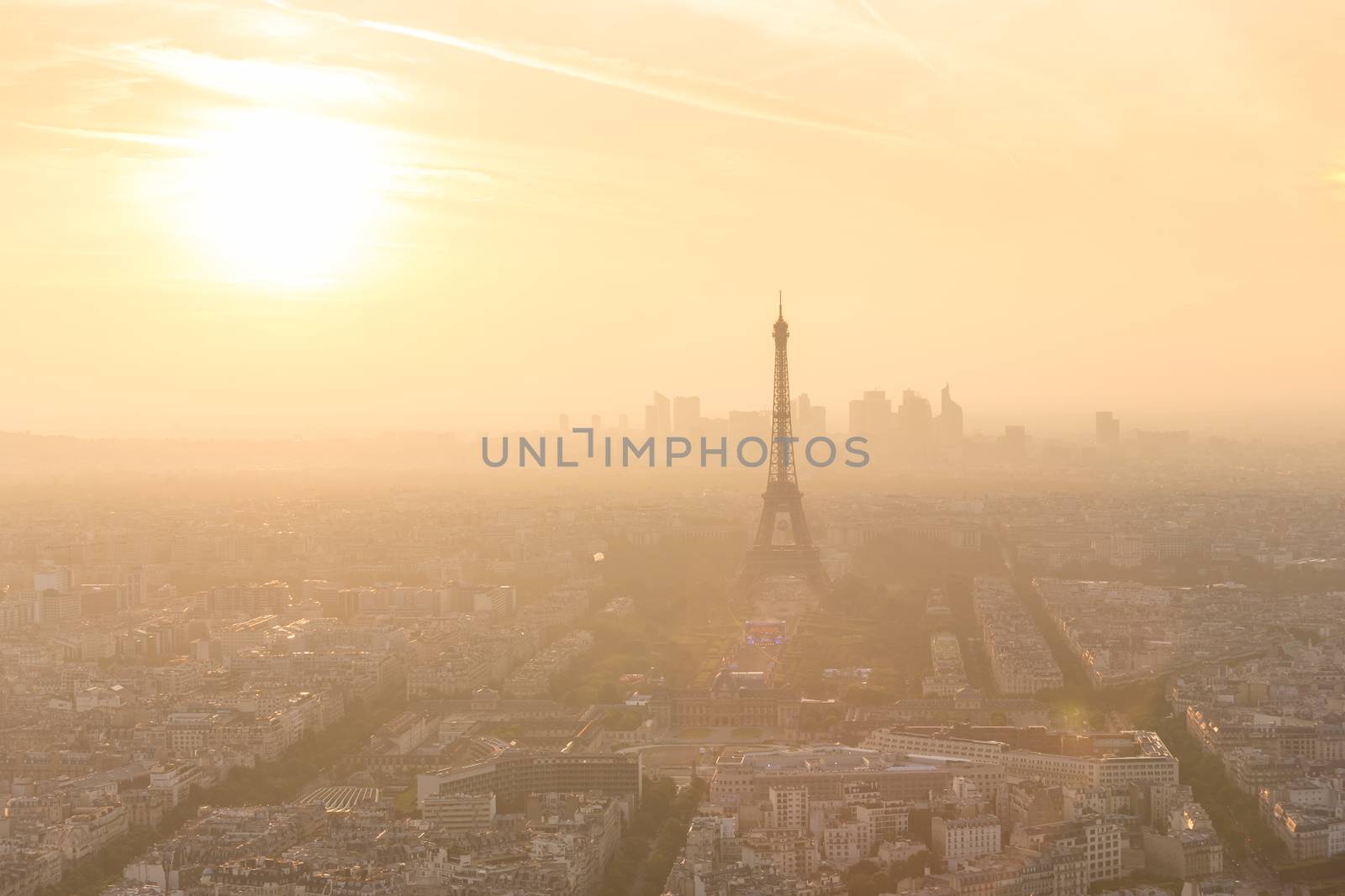 Aerial view of Paris with Eiffel tower and major business district of La Defence in background at sunset.