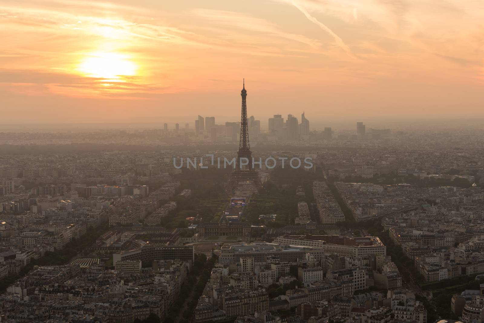 Aerial view of Paris with Eiffel tower and major business district of La Defence in background at sunset.