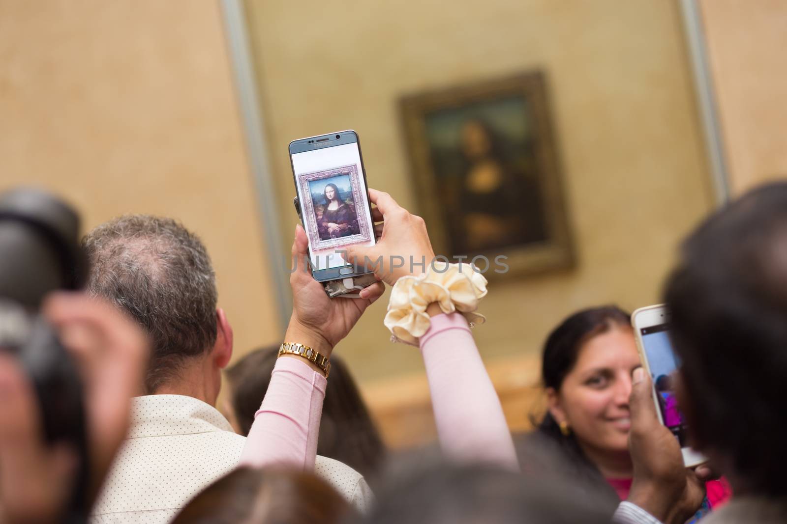 Paris, France - June 12: Crowd of visitors takes photos of Leonardo DaVinci's Mona Lisa, one of world's most famous work of art, at Louvre Museum on 12th of June ,2016 in Paris, France.