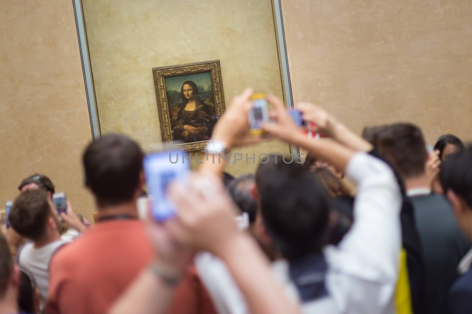 Paris, France - June 12: Crowd of visitors takes photos of Leonardo DaVinci's Mona Lisa, one of world's most famous work of art, at Louvre Museum on 12th of June ,2016 in Paris, France.