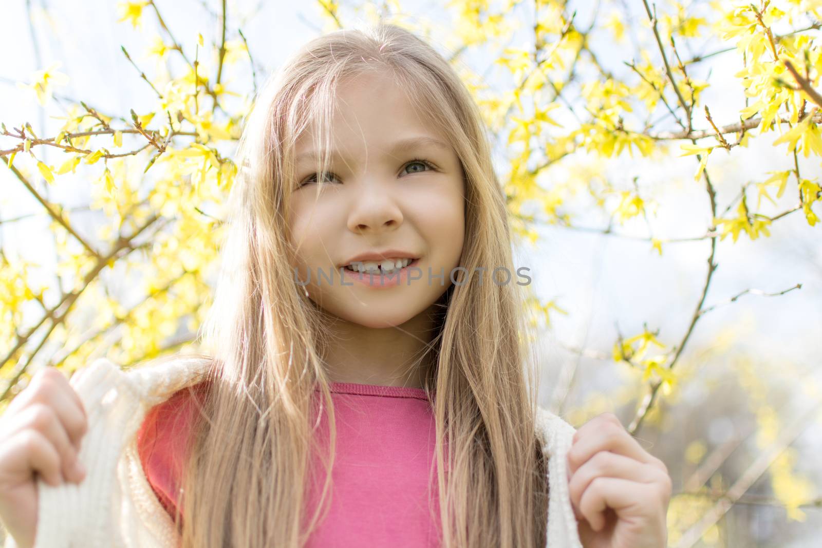 Beautiful little girl in the park in spring.