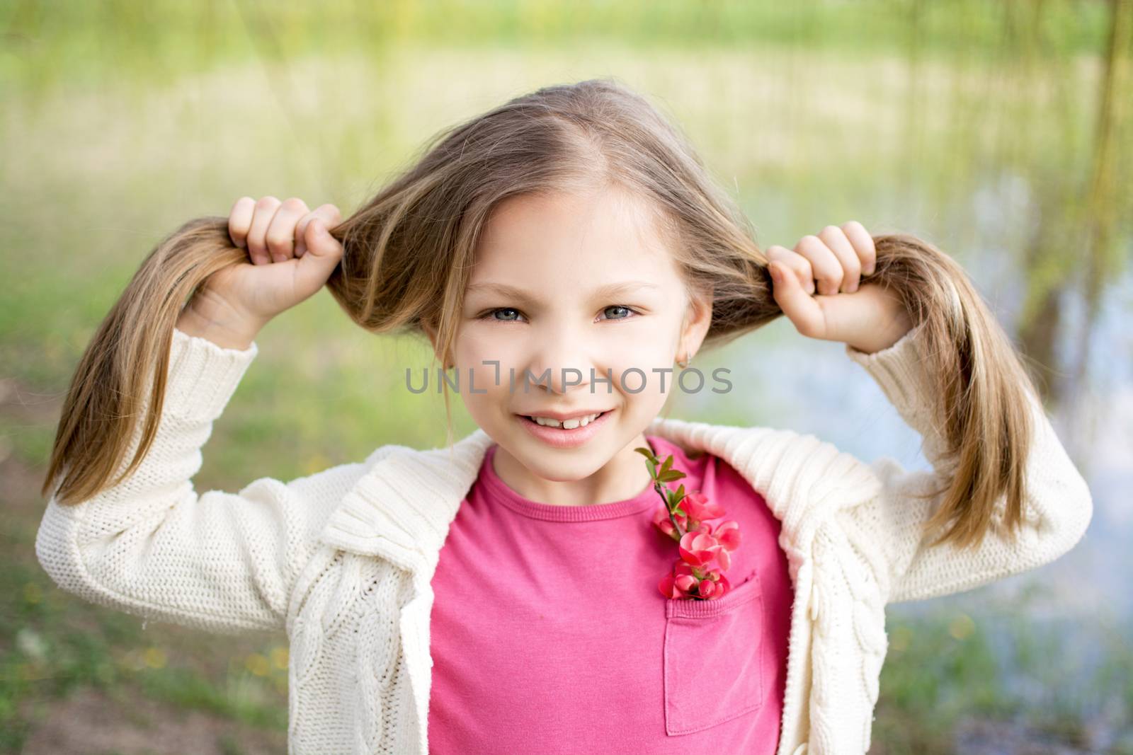 Beautiful funy little girl in the park in spring.