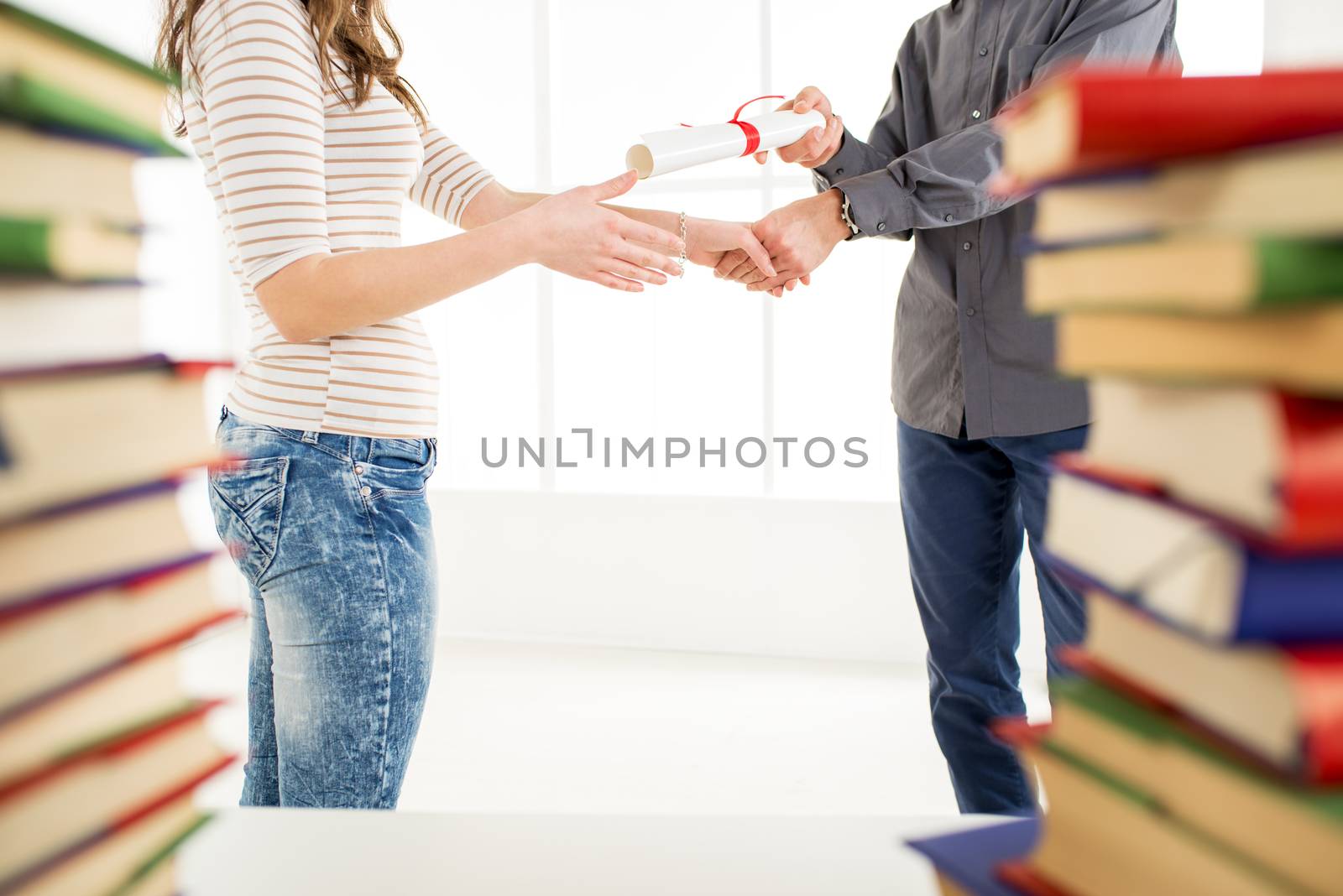 Close-up of woman and man hands is holding diplomas and shaking hands