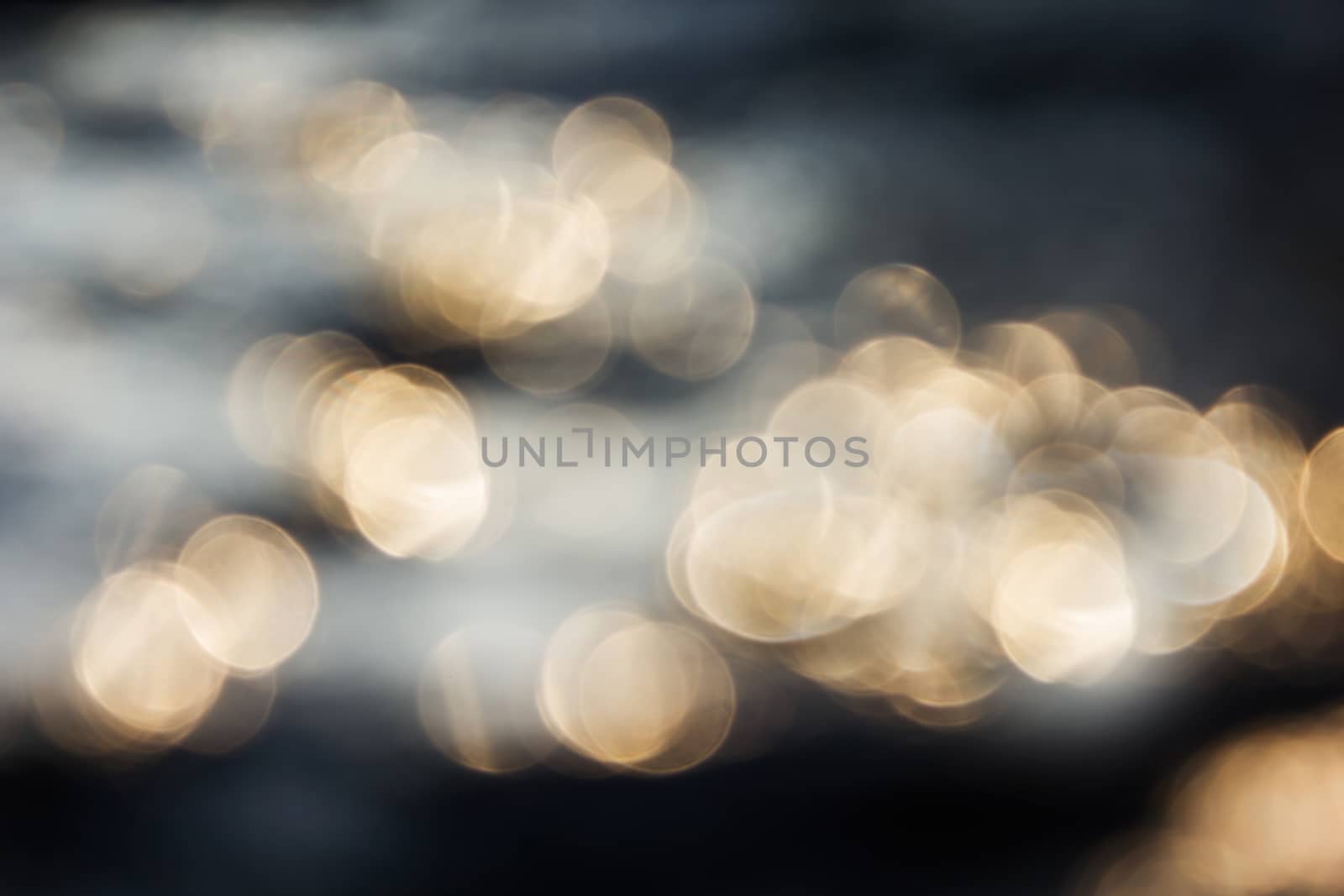 Dreamy abstract sparkle shining orange golden bokeh light crystalline water in river surface romantic background, gold bokeh on dark