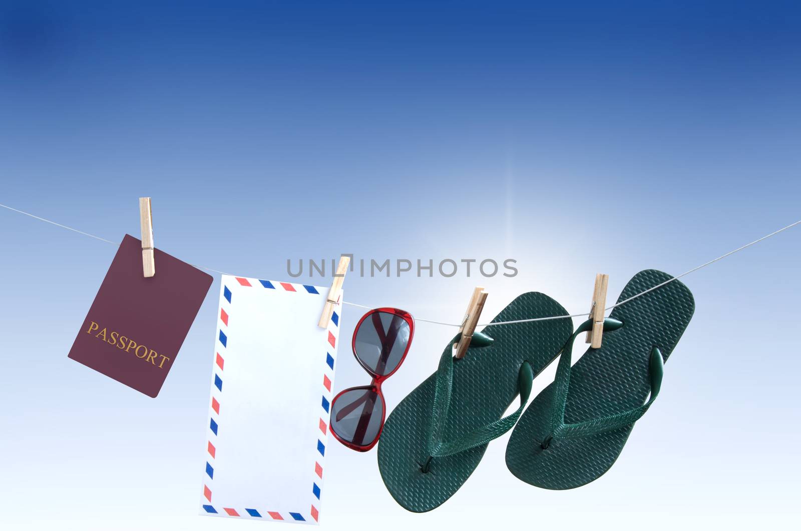 Summer items hanging on a washing line including passport, flip flops, sunglasses and international mailing envelope