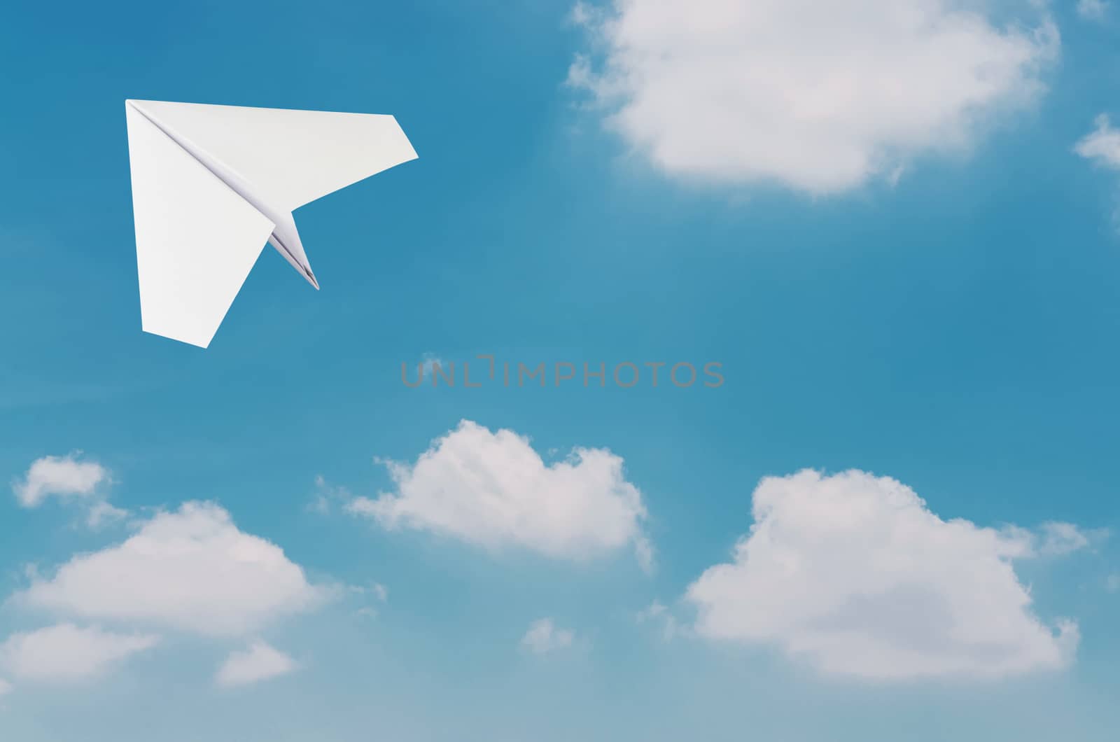 Paper plane flying over clouds with blue sky. by koson