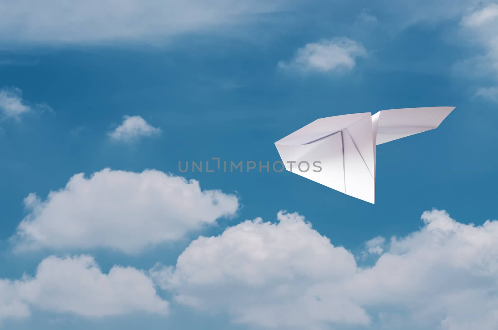 Paper plane flying over clouds with blue sky. by koson