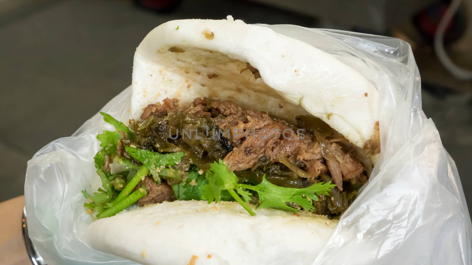 The close up of Taiwanese Pork Steamed Sandwich bun (gua bao) at food street market in Taipei, Taiwan.