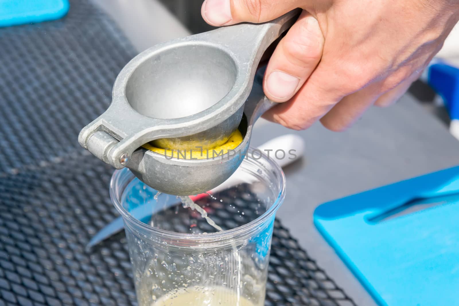 the manual metal juicer lemon in a plastic Cup