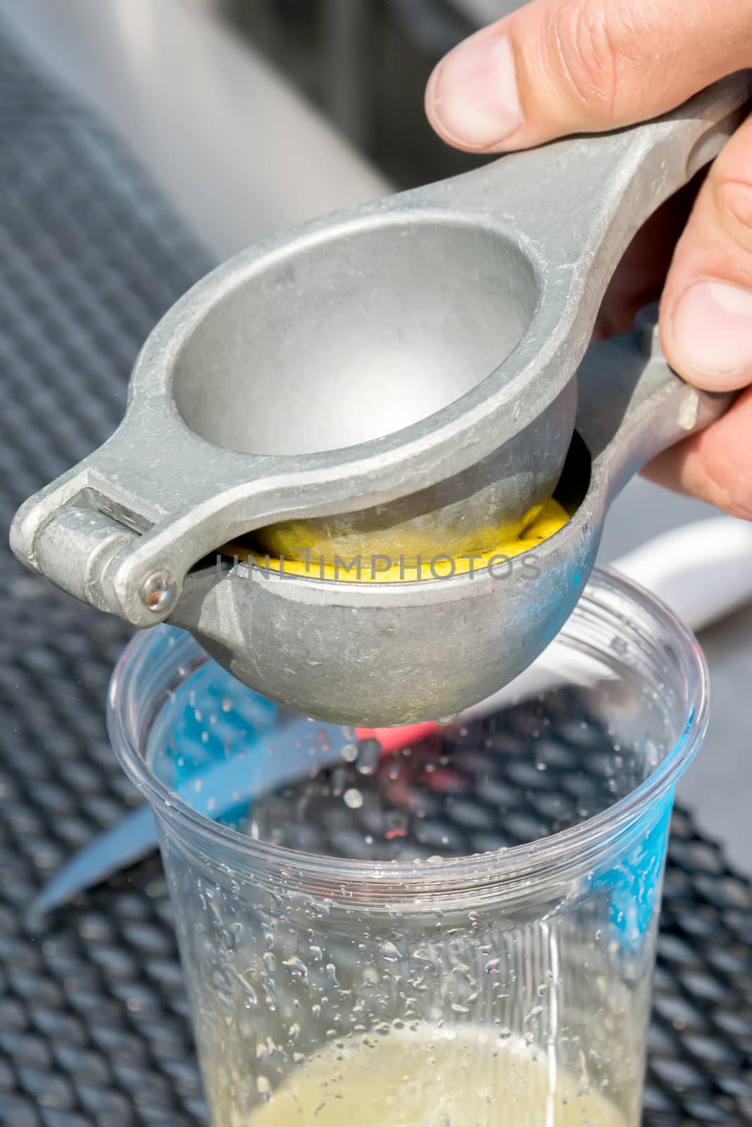 the manual metal juicer lemon in a plastic Cup