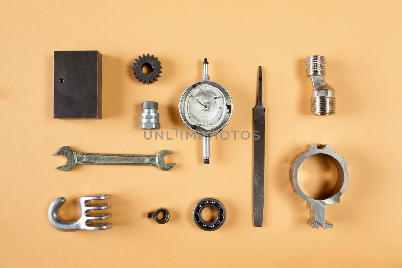 Mixture of different pieces of tools and machinery on orange background