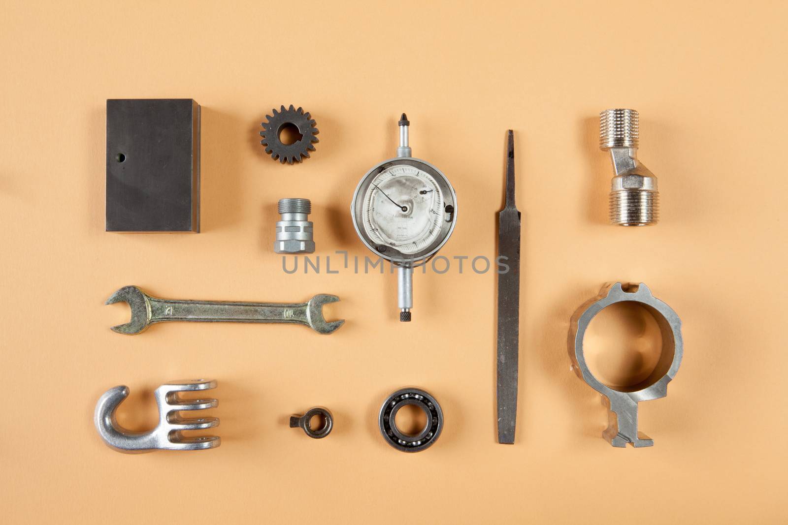 Mixture of different pieces of tools and machinery on orange background