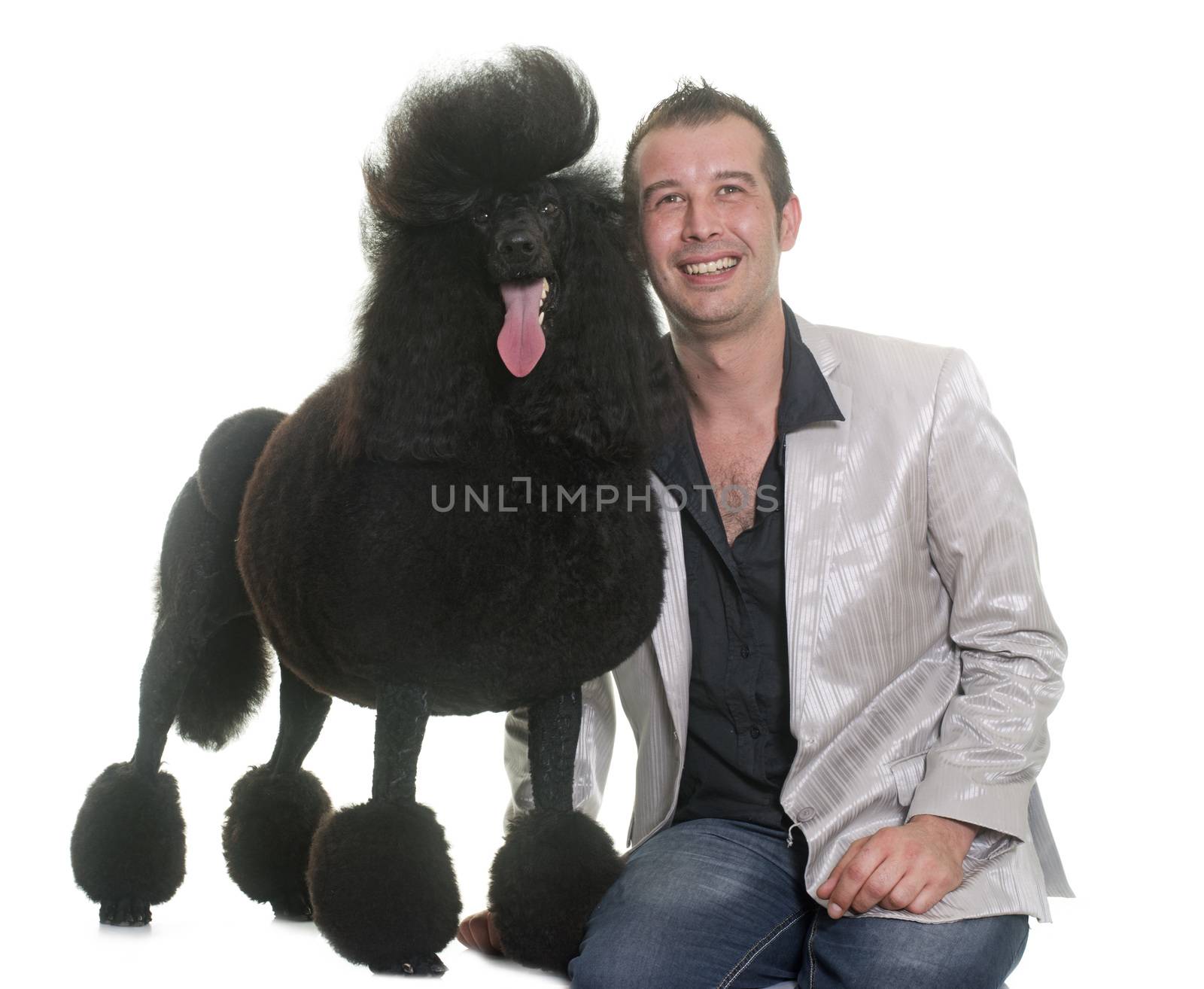 man and standard poodle in front of white background