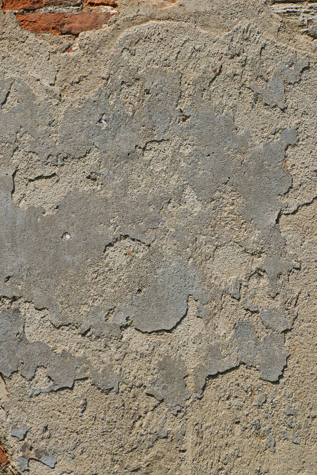 Background texture of old grey painted plaster wall with grunge stains and bricks