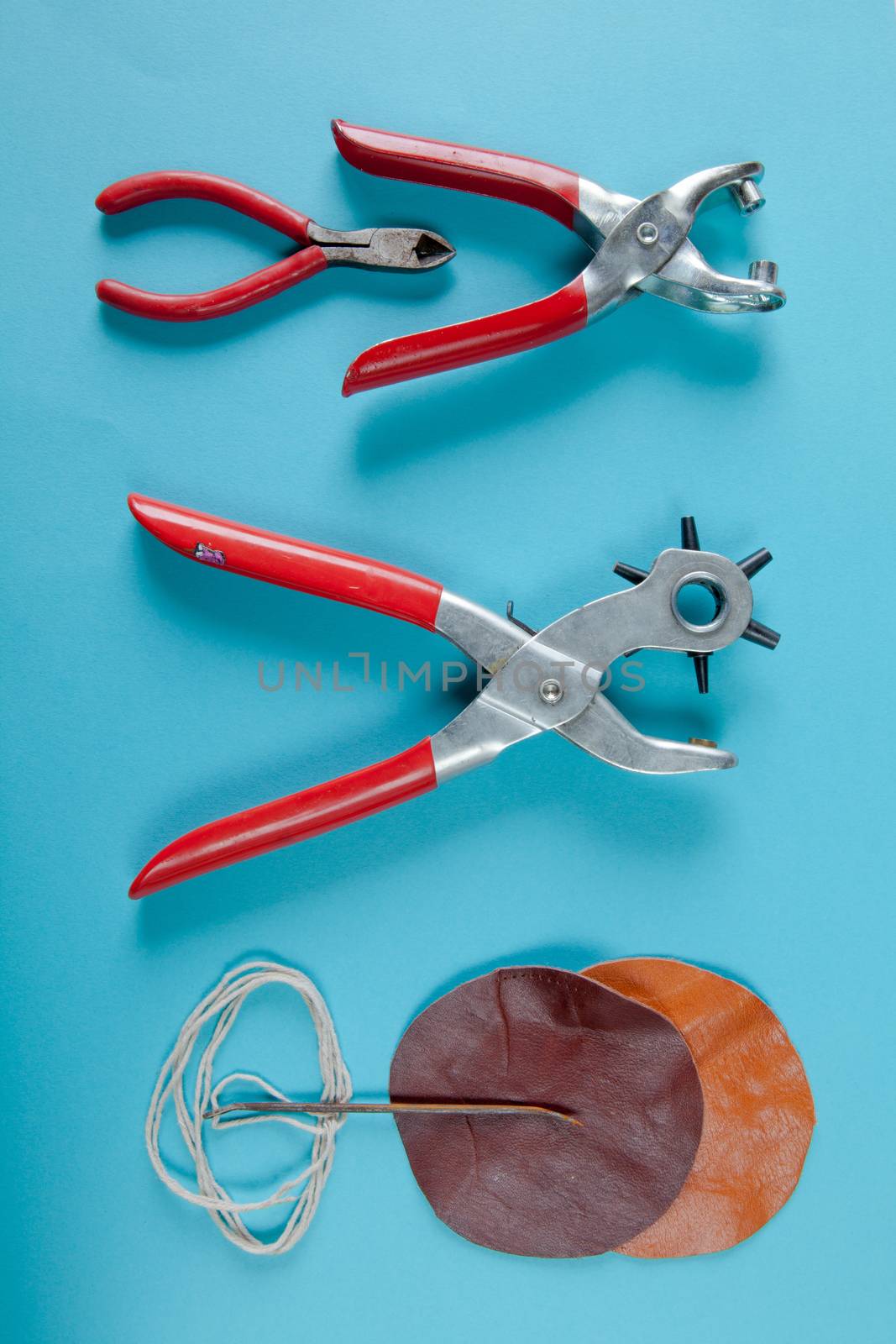 Working tools for embossed leather on blue background top view