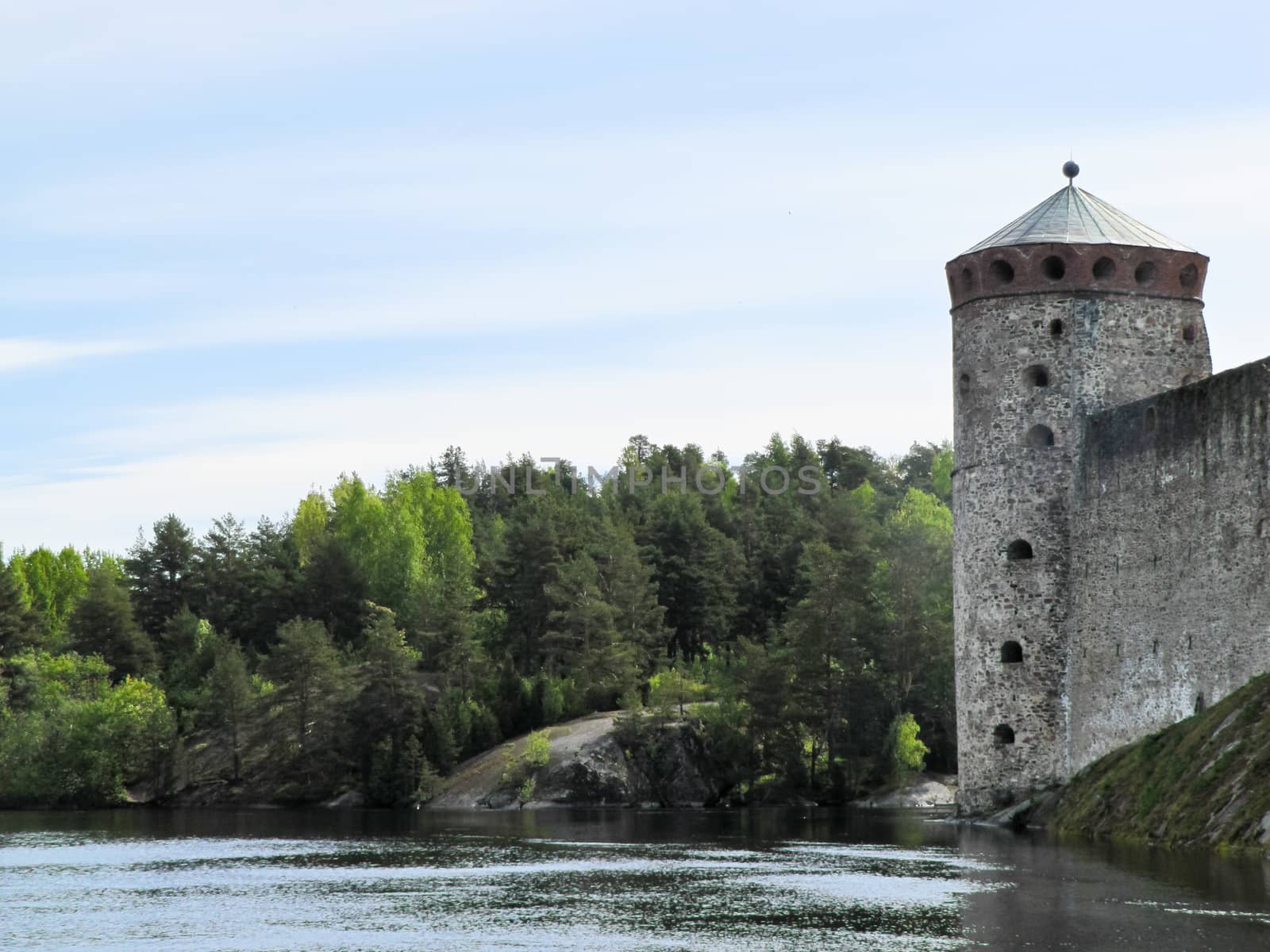 old castle by the river on a background of forest and blue sky