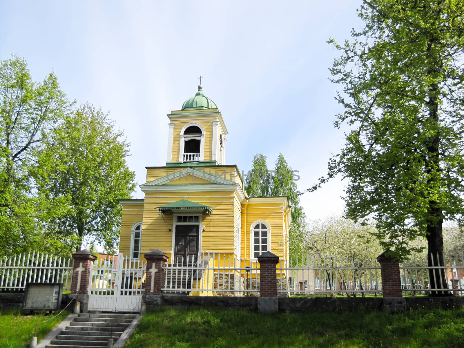 wooden Church in yellow on a blue sky background
