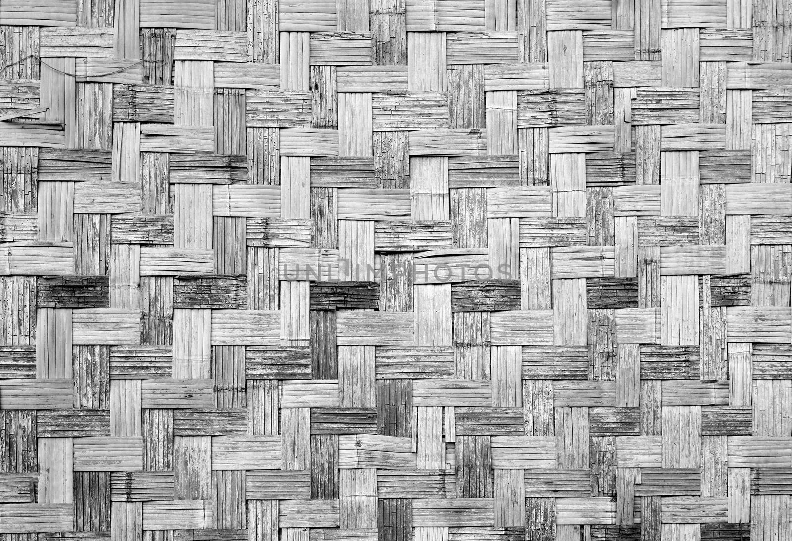 Wall of plaited bamboo strips vernecular outdoor grey scale by polarbearstudio