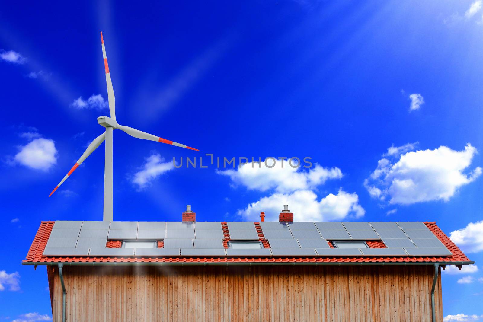 Solar panels and wind turbine against a sunny sky.