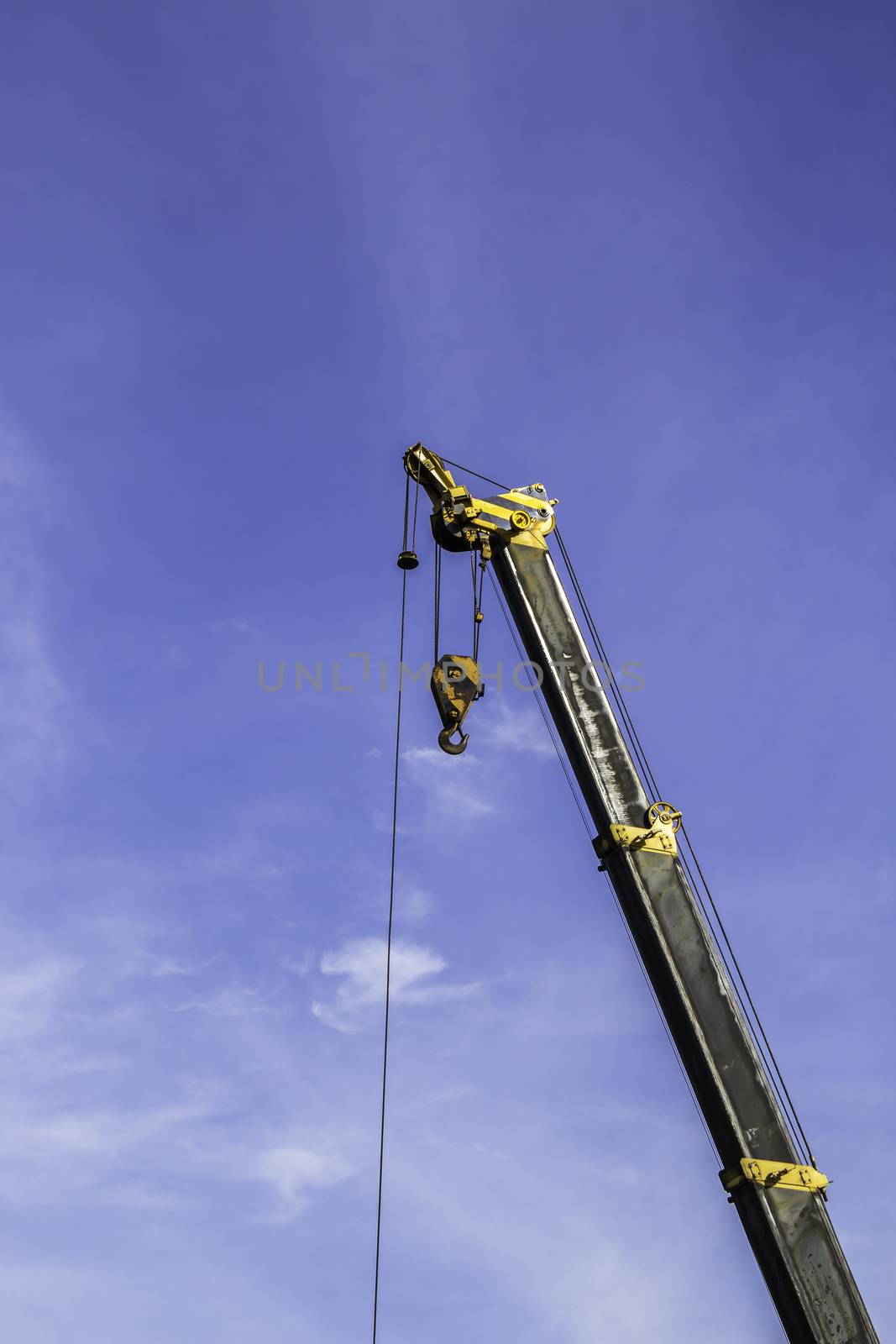Industrial crane and hook white blue sky background