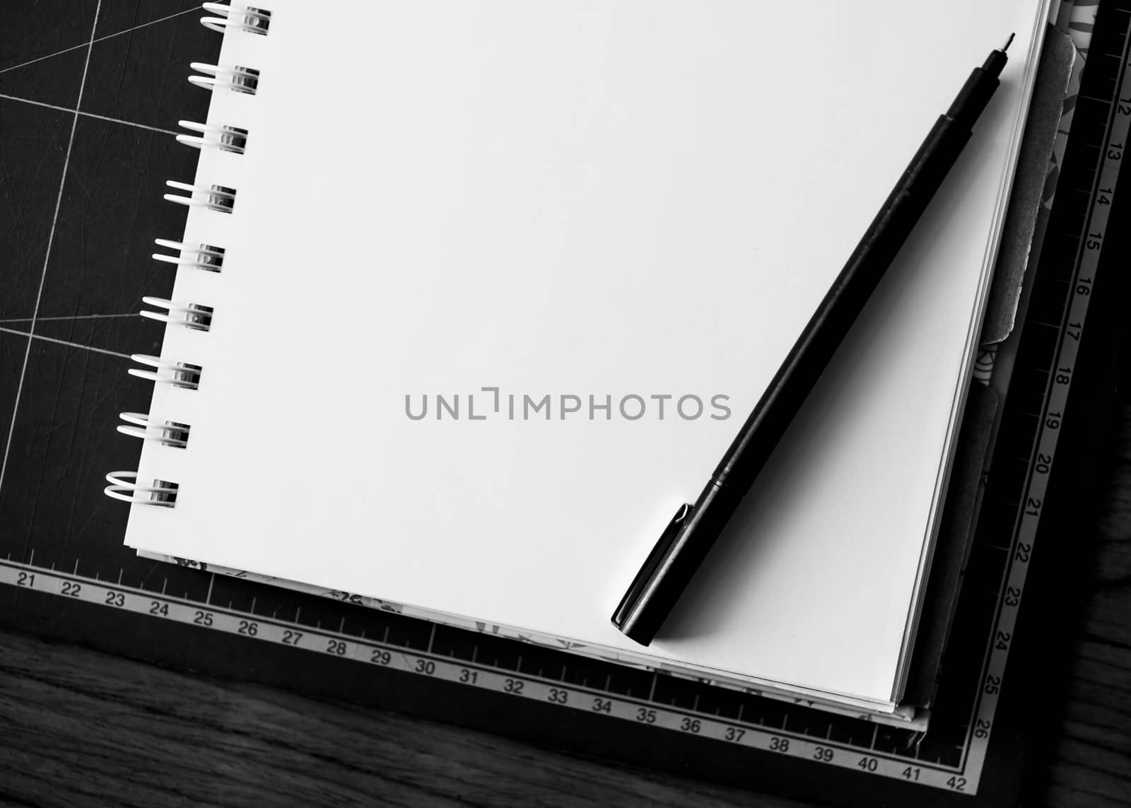 Blank notebook with pen on the table. black and white image.