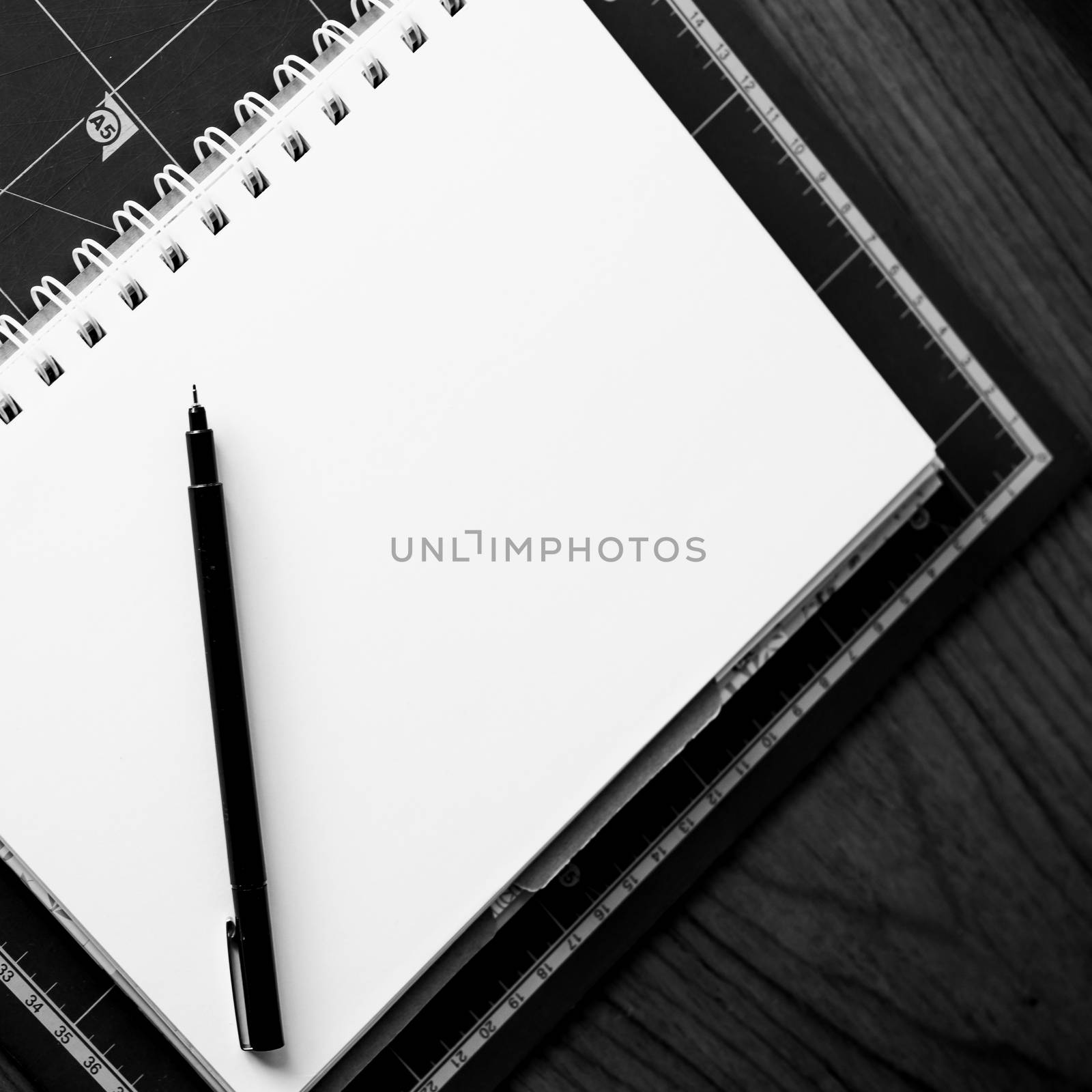 Blank notebook with pen on the table. black and white image.