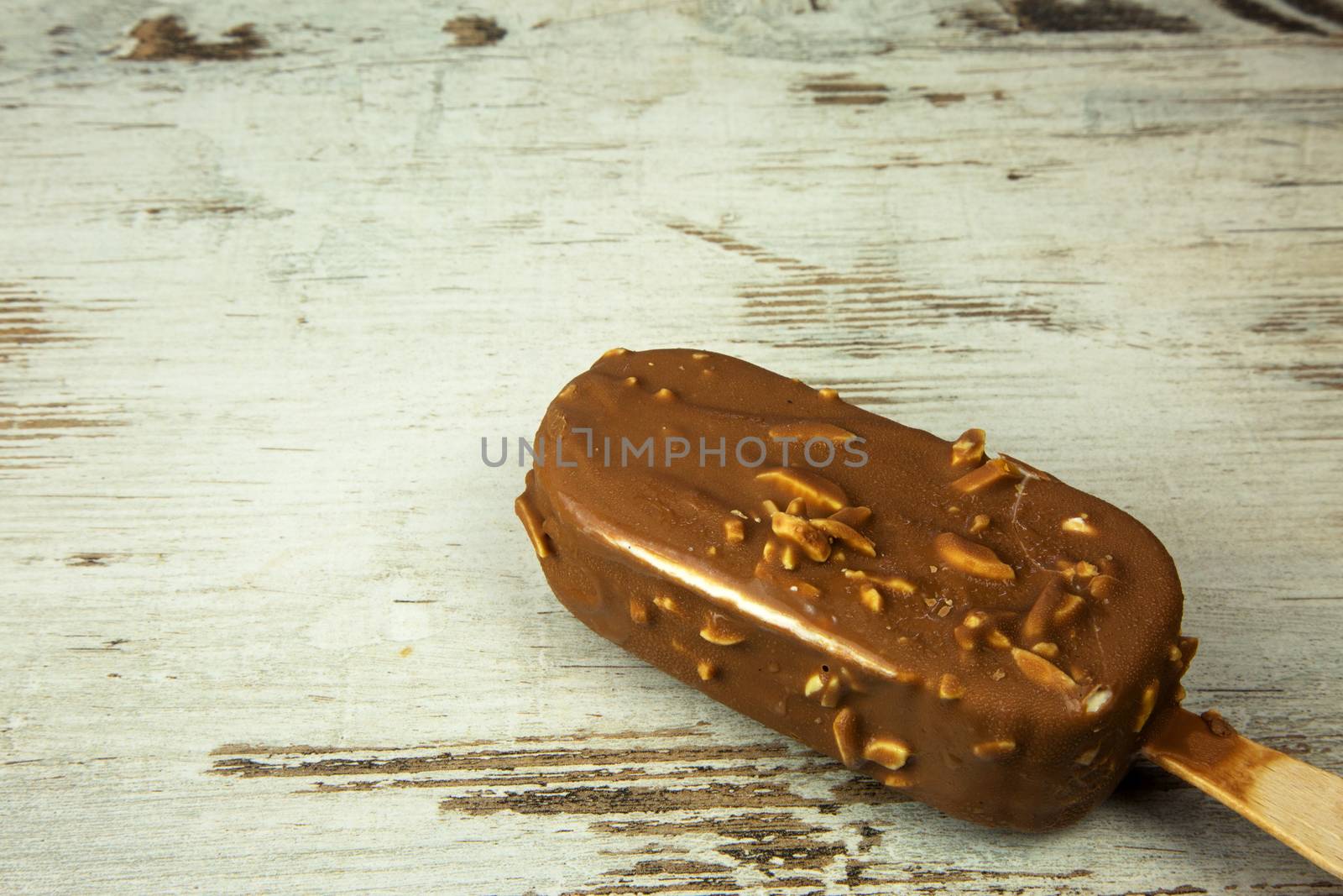 Chocolate ice lolly on a light wooden countertop in vintage style. Flat , horizontal view.