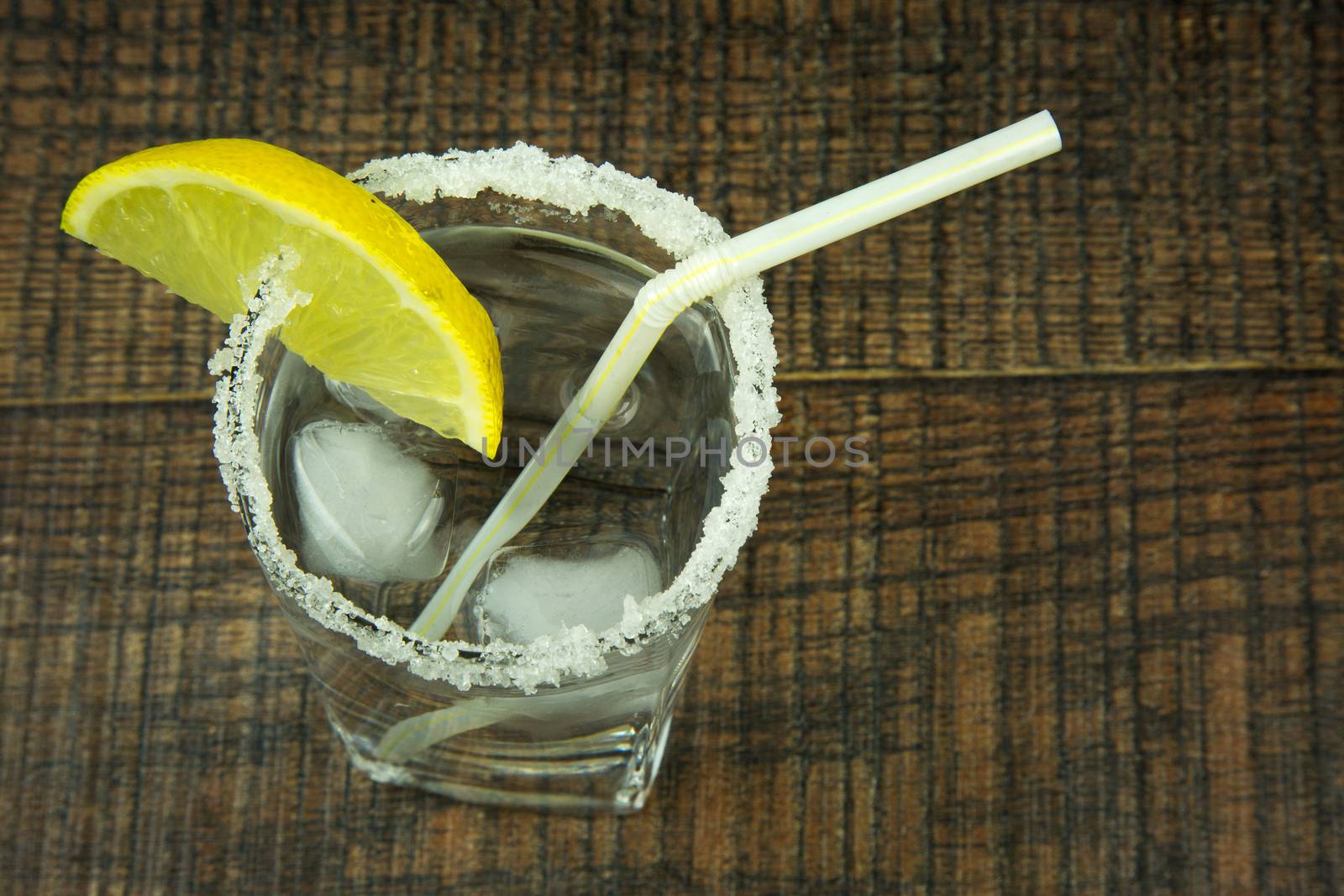 Glass from the shores of decorative sugar, full of cold water with ice and lemon, refreshing drink for the summer. flat, horizontal view.