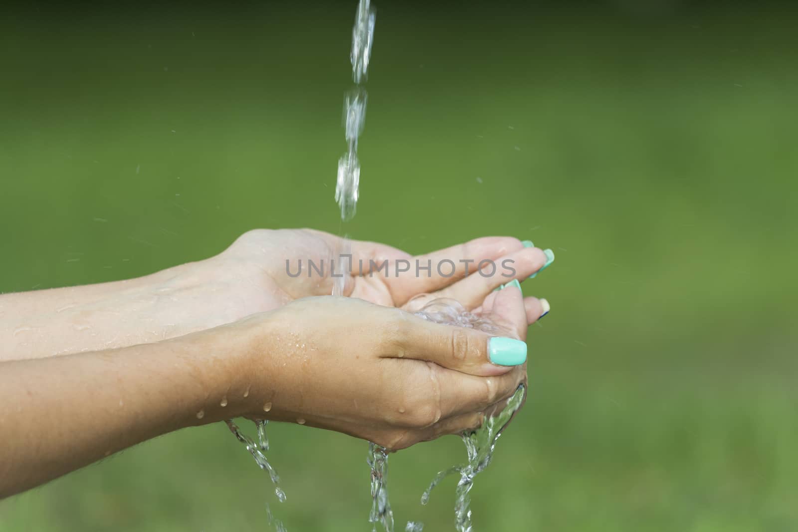 Clean water flows from the fingers of a young girl