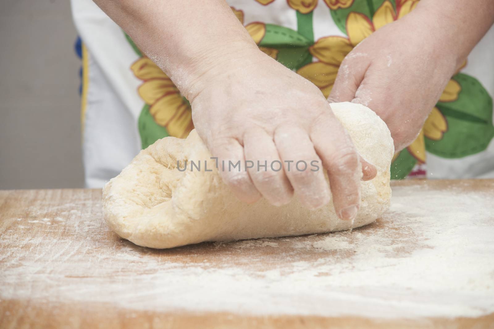 Women's hands preparing fresh yeast dough on wooden table