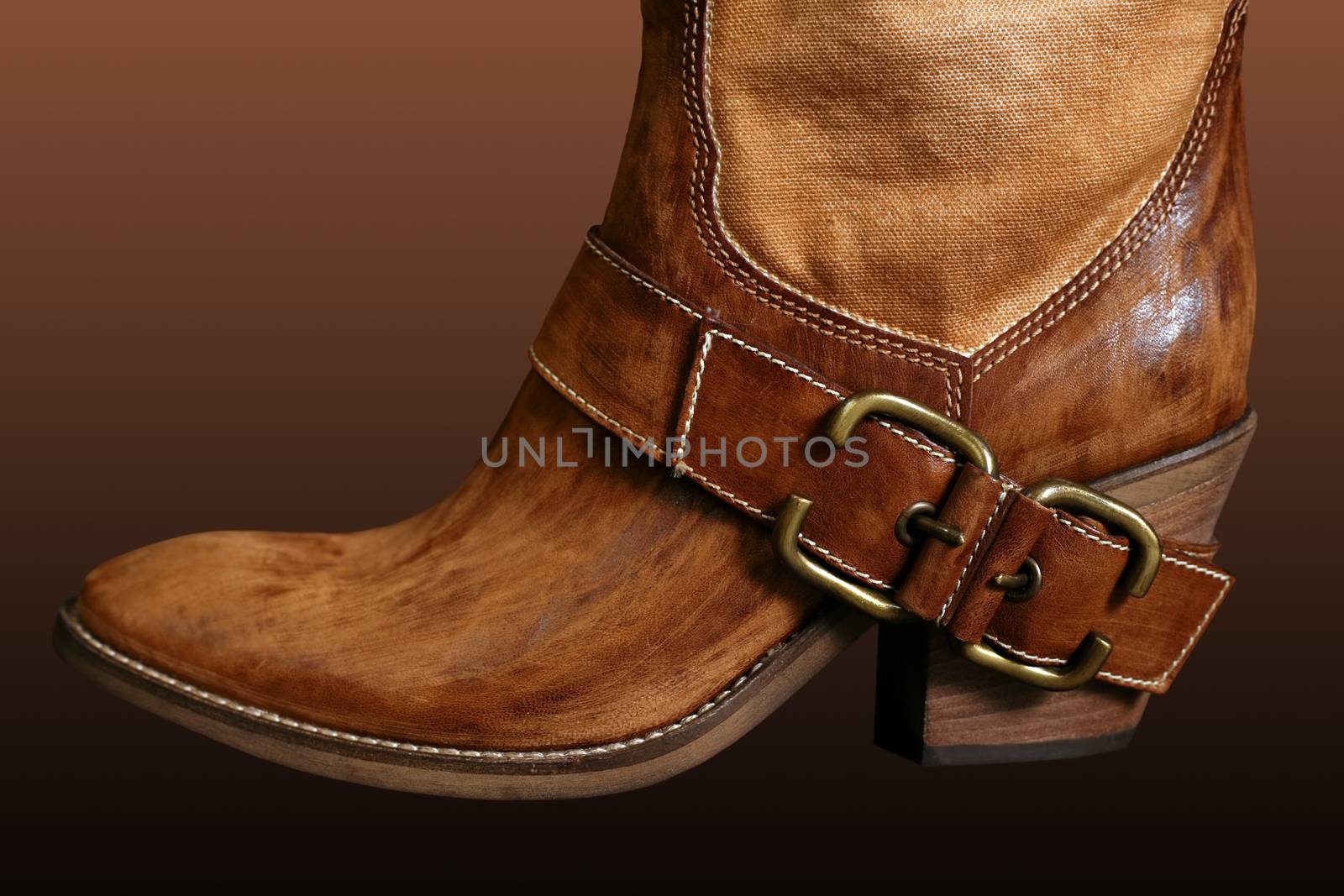 Female boot of the cowboy on a dark background
