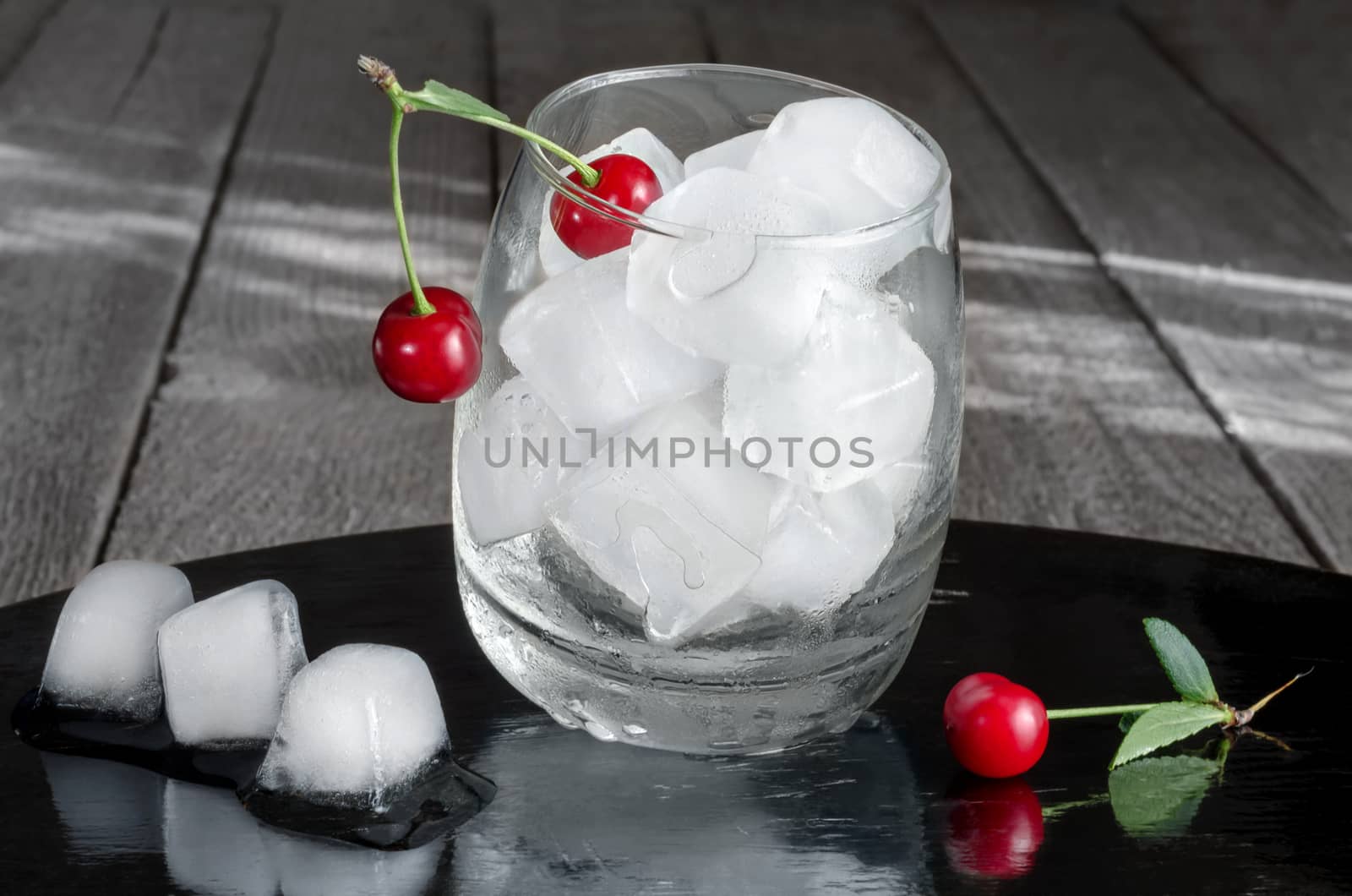 Ice cubes in a glass and cherries