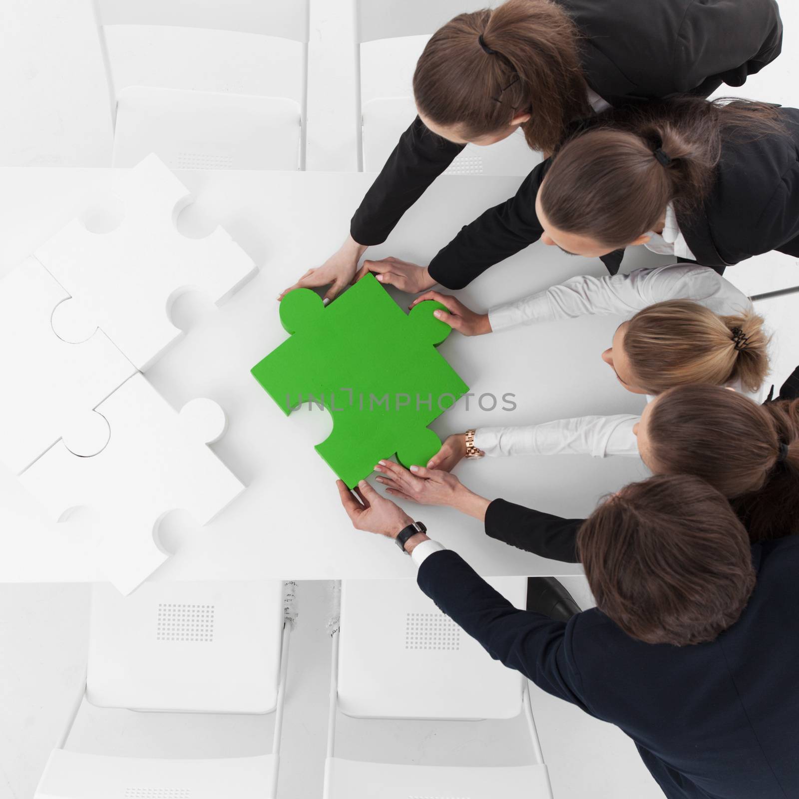 Group of business people assembling jigsaw puzzle