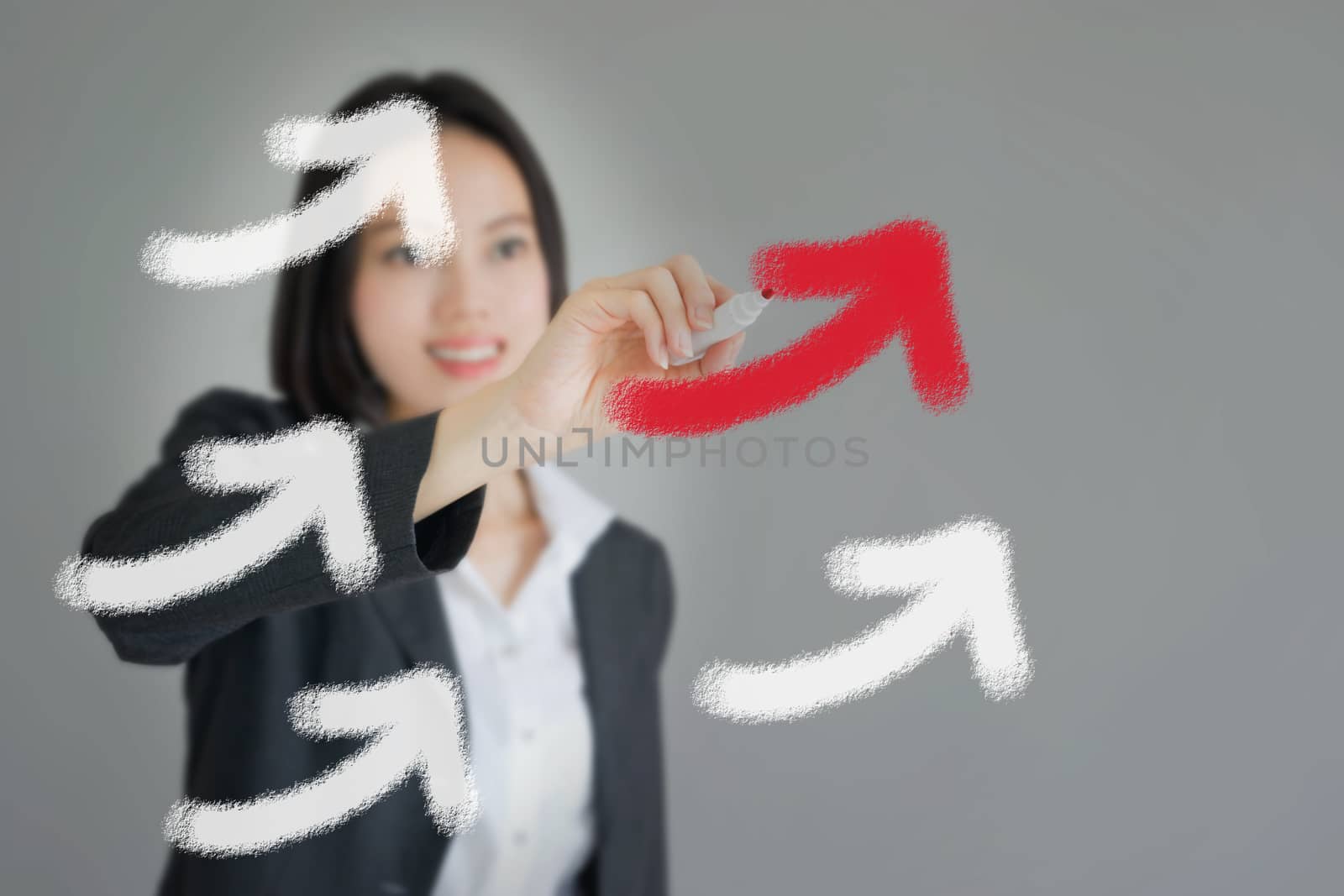 Young beautiful businesswoman drawing rising arrows