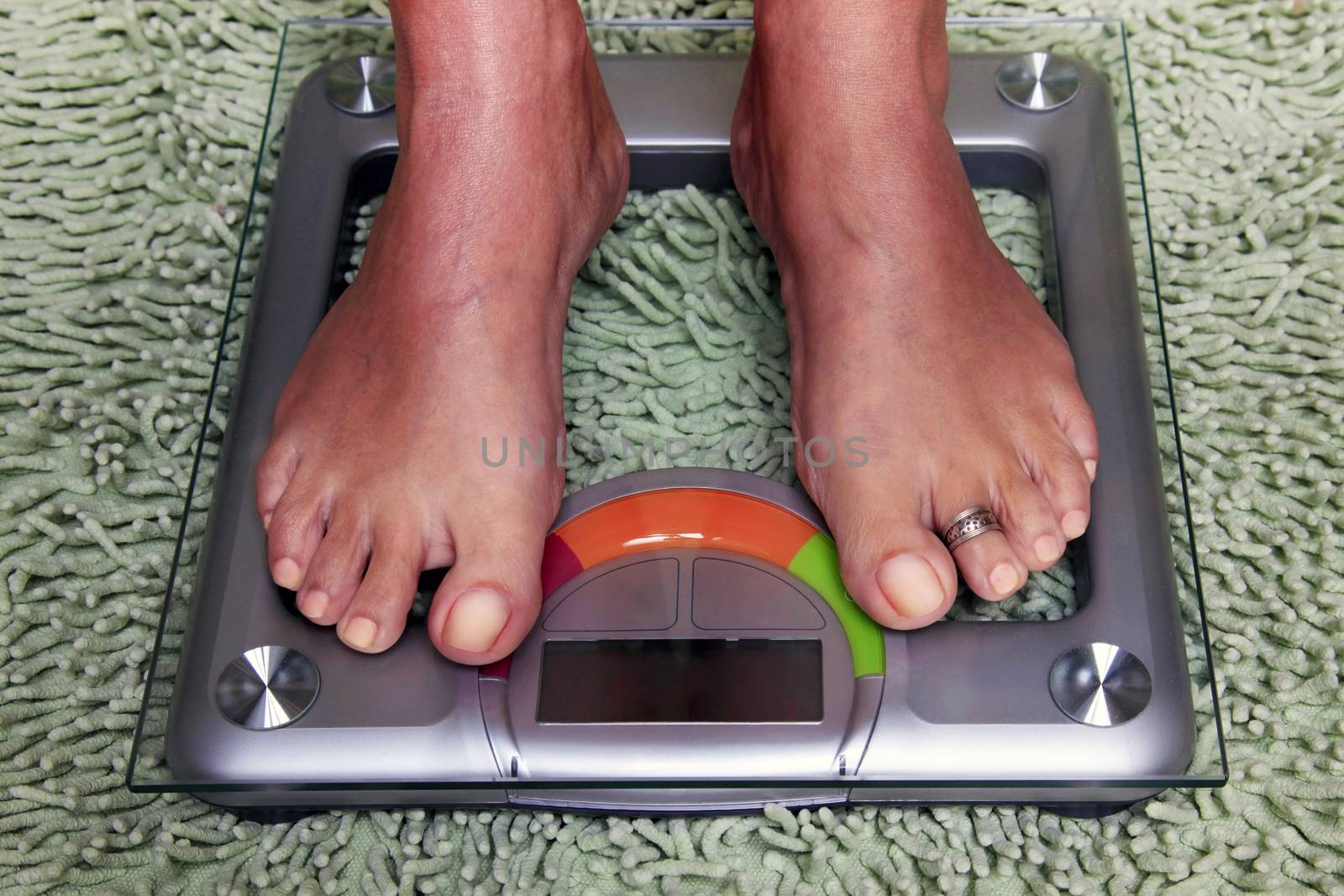 Bathroom scales isolated against green carpet
