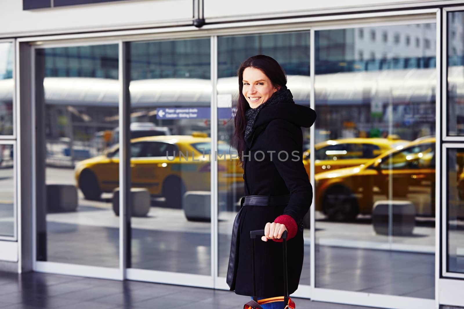 Successful woman in front of the terminal at the airport.