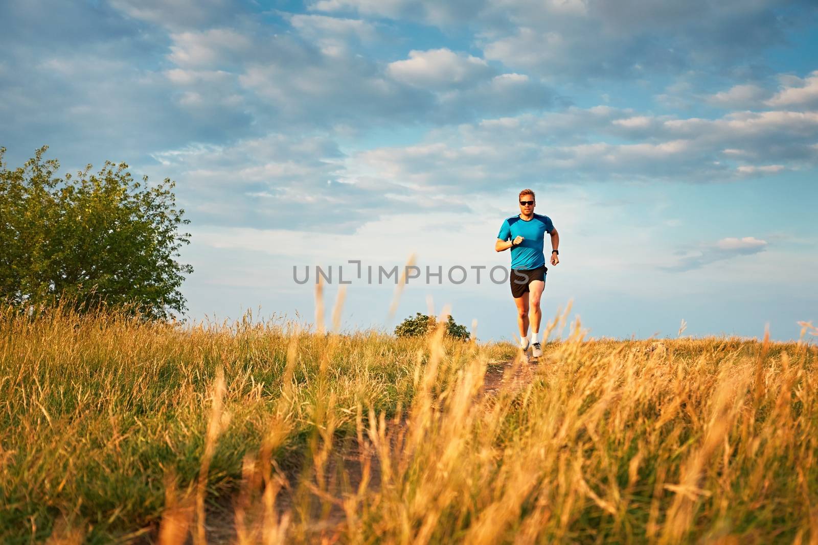 Athletic runner on the hillside by Chalabala