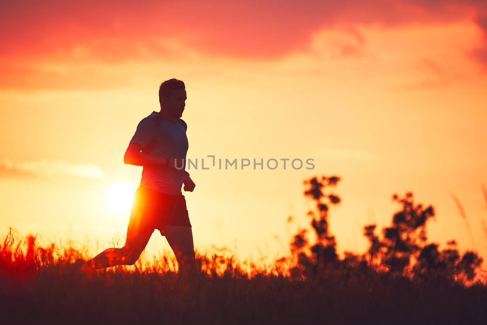 Athletic runner at the sunset by Chalabala
