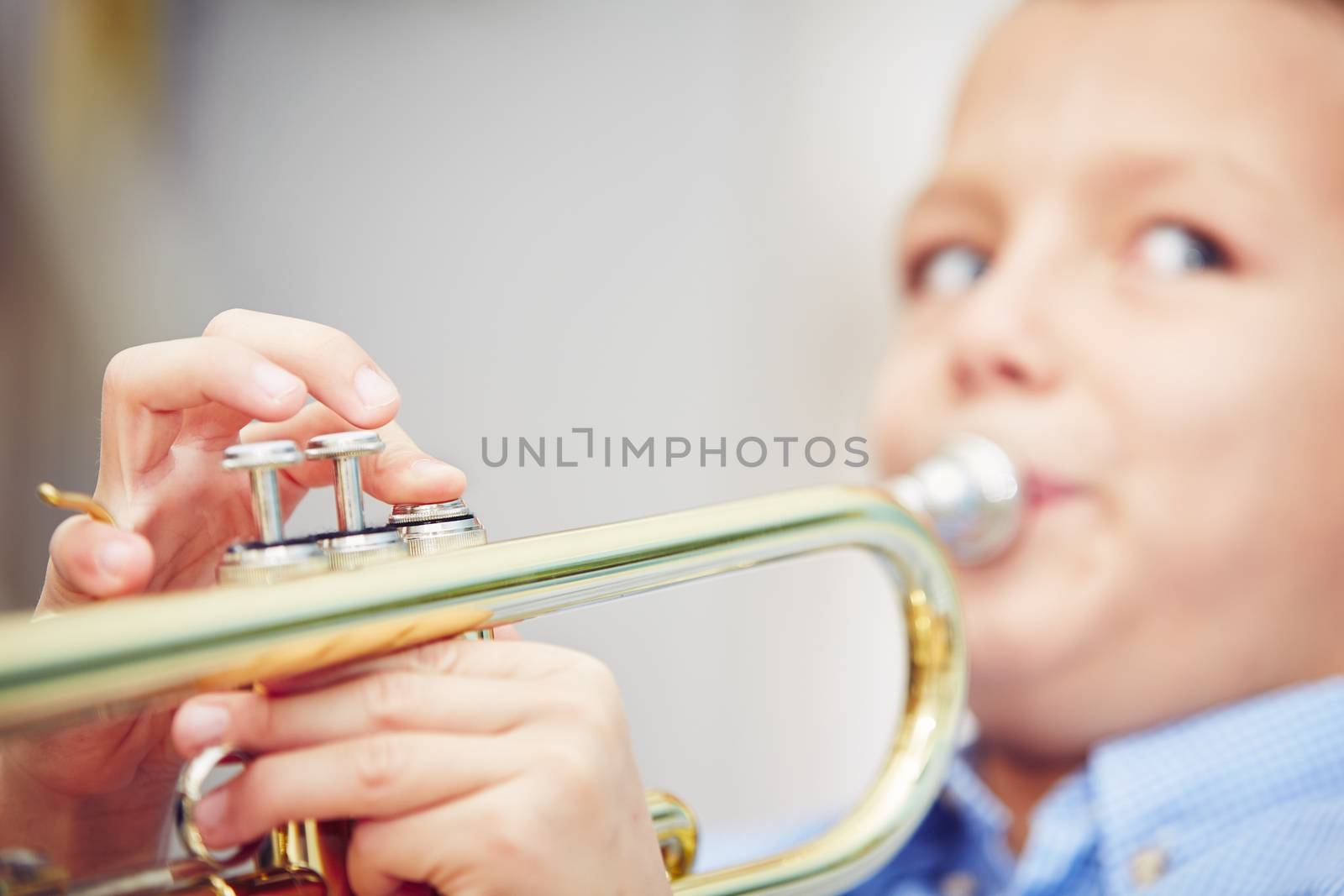 Little boy is playing the trumpet at home 