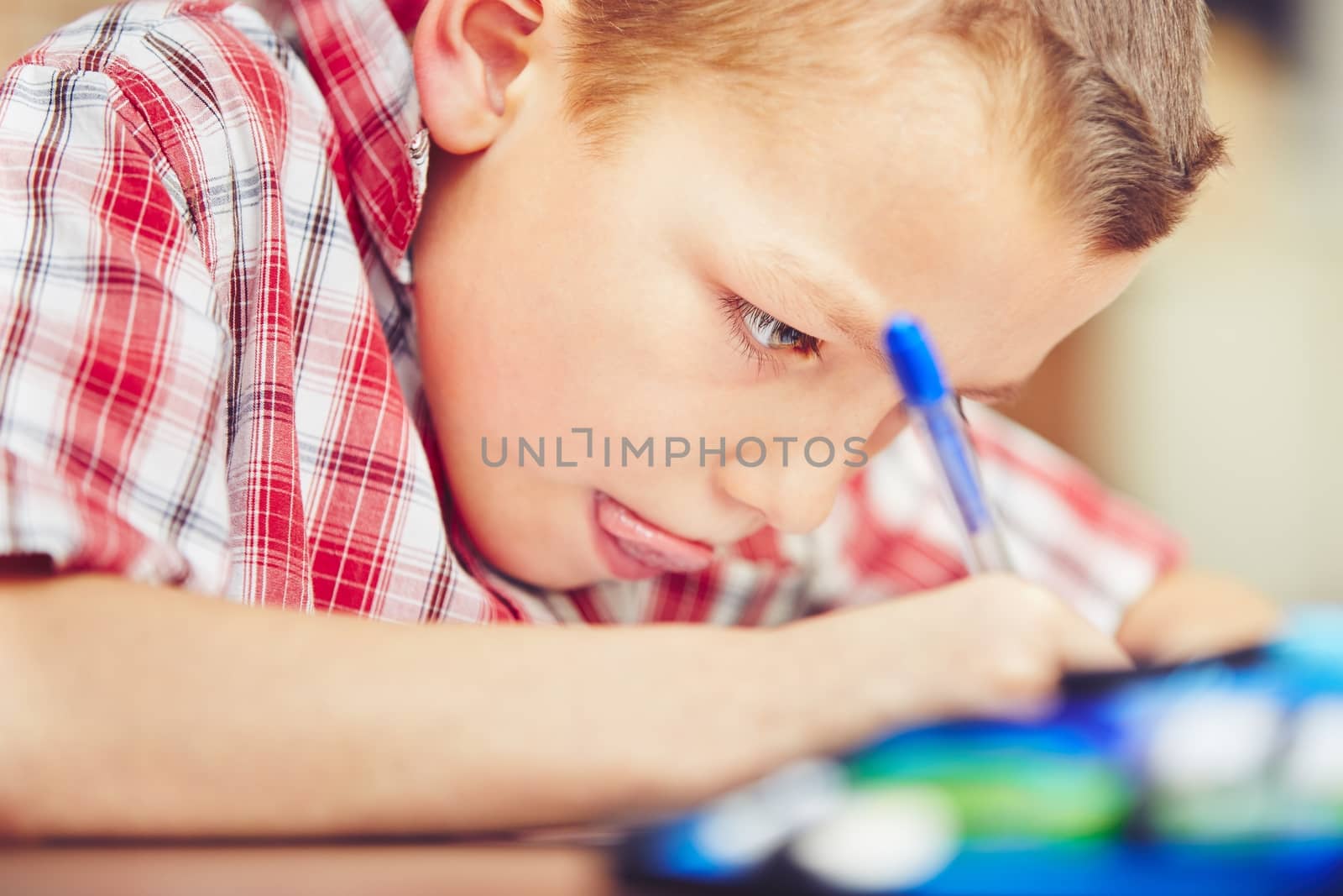 Little boy is doing his homework for elementary school.